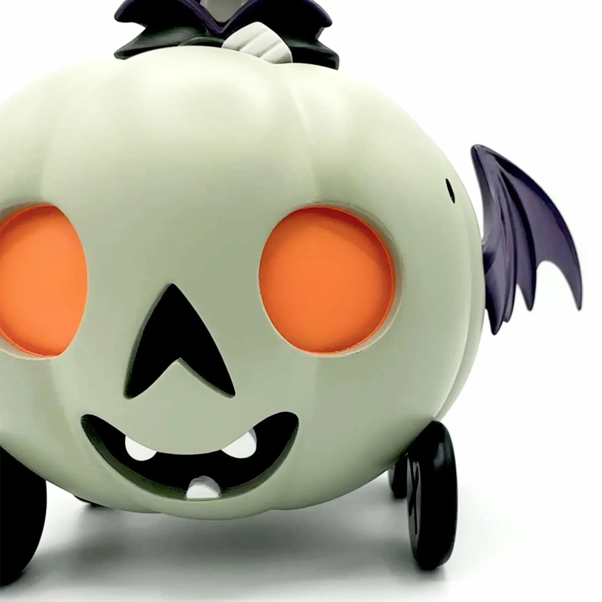 Stephanie Buscema Ghostly Gourd Racer close-up showing jack-o-lantern face with orange eyes, bat wing, and button wheels