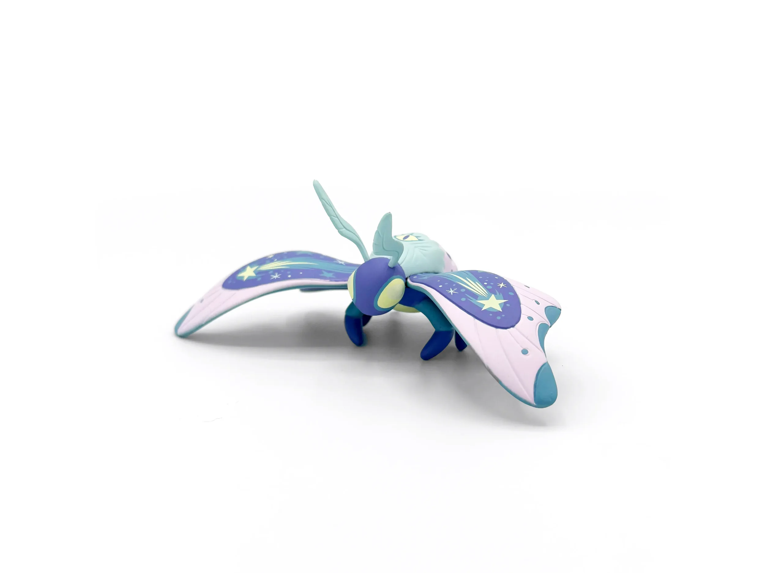 Stephanie Buscema Astroptera Stelle vinyl moth art toy, three-quarter front view in lilac, purple, and blue
