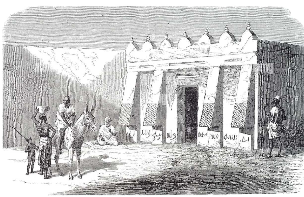 Historical black and white illustration of an ancient Egyptian temple entrance with four large columns, decorated with hieroglyphics, flanked by statues and surrounded by people, including a man on horseback, a seated person, and others in traditional attire.