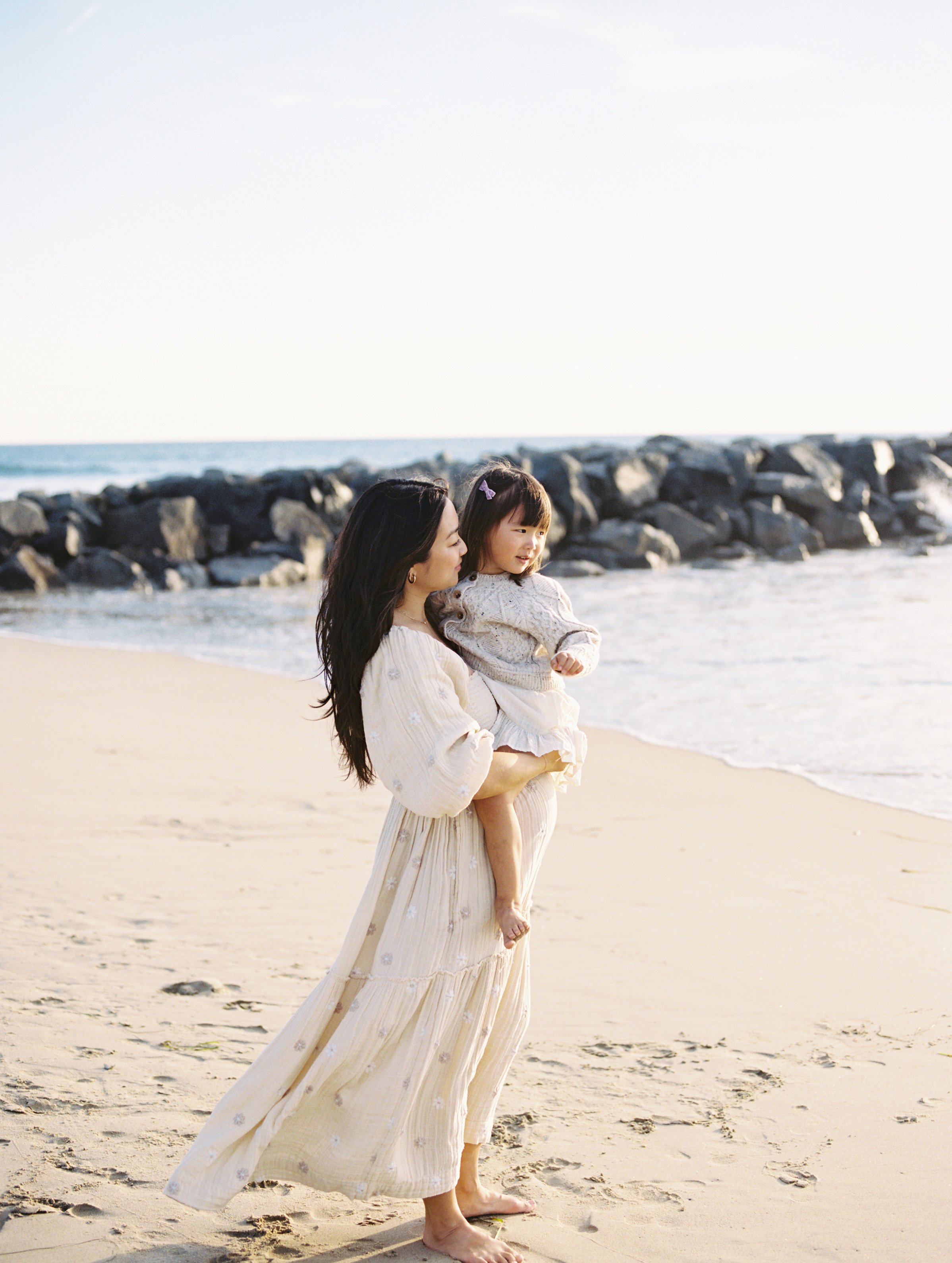 Coastal motherhood portrait captured during a relaxed family photography session in Newport Beach, California.
