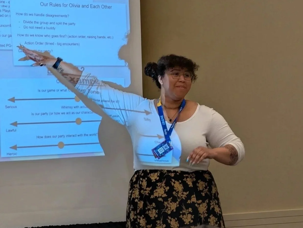Liv, a Game Master from Young Dragonslayers, presents at a conference on D&D and social skills for kids.