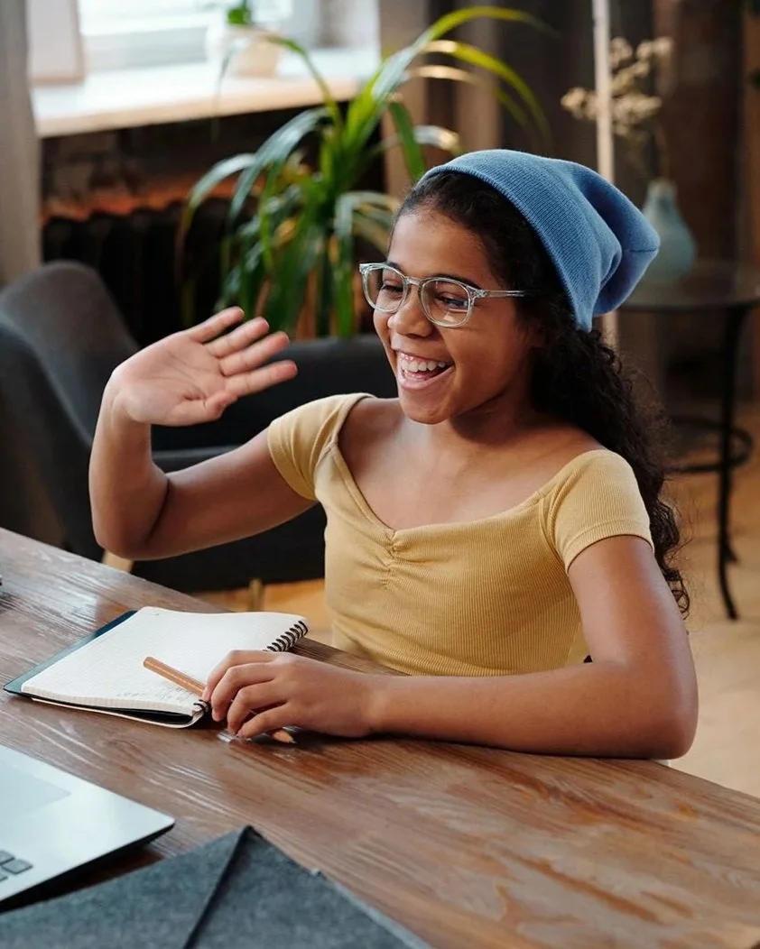 Girl waving to others during an online D&D group.