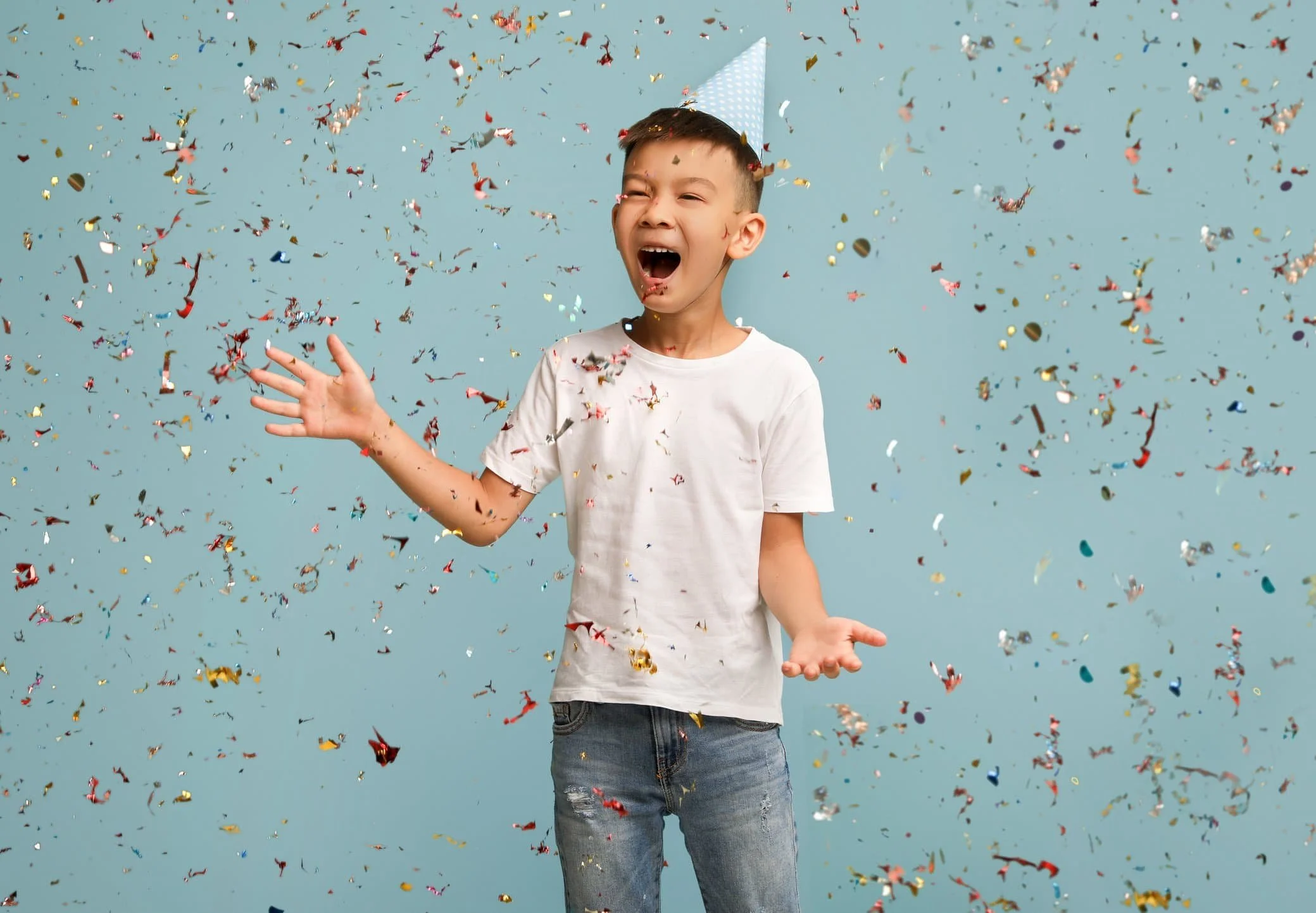 A tween boy celebrates with confetti at his Dungeons and Dragons birthday party.