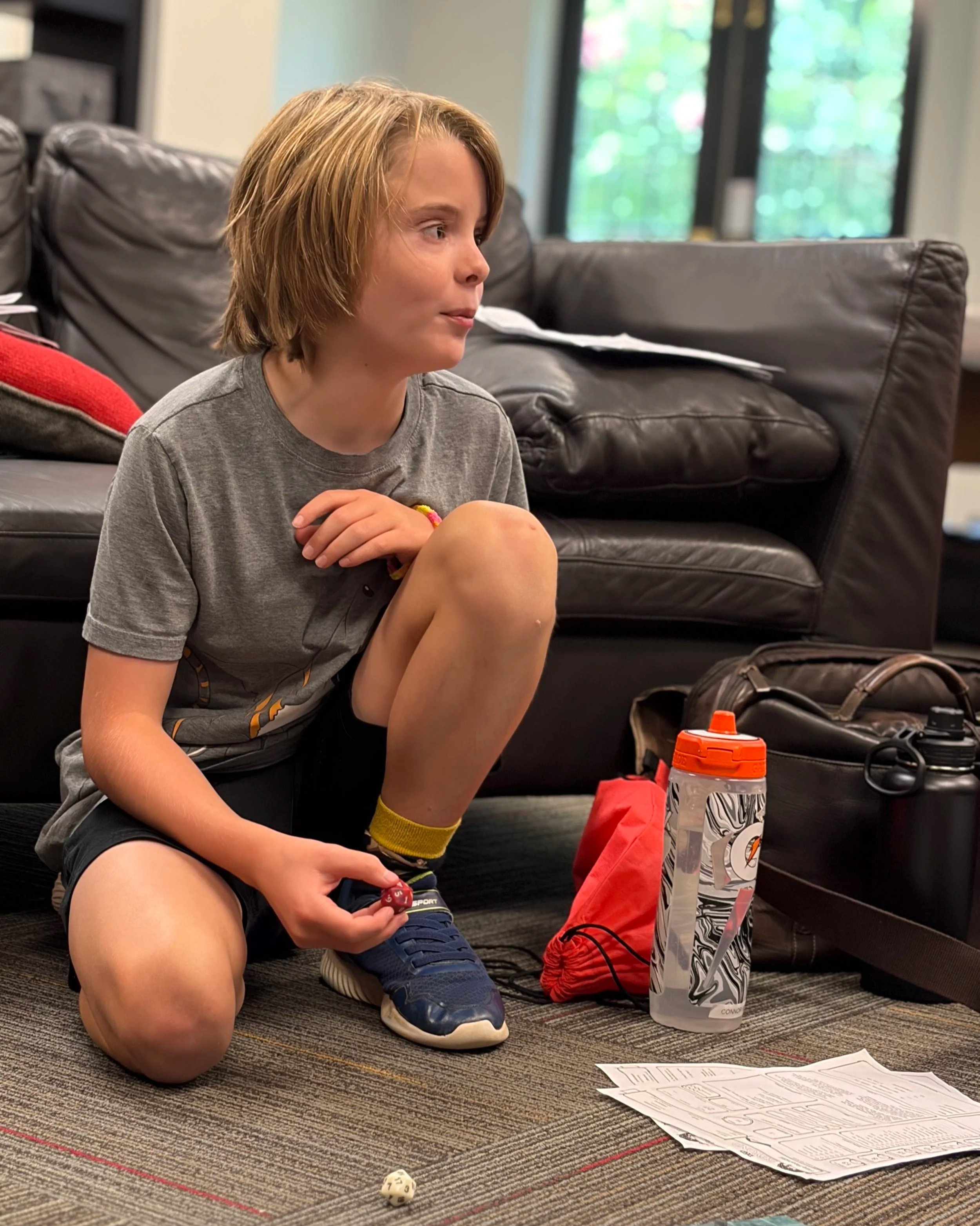 A boy prepares to roll a twenty-sided die at DND summer camp.