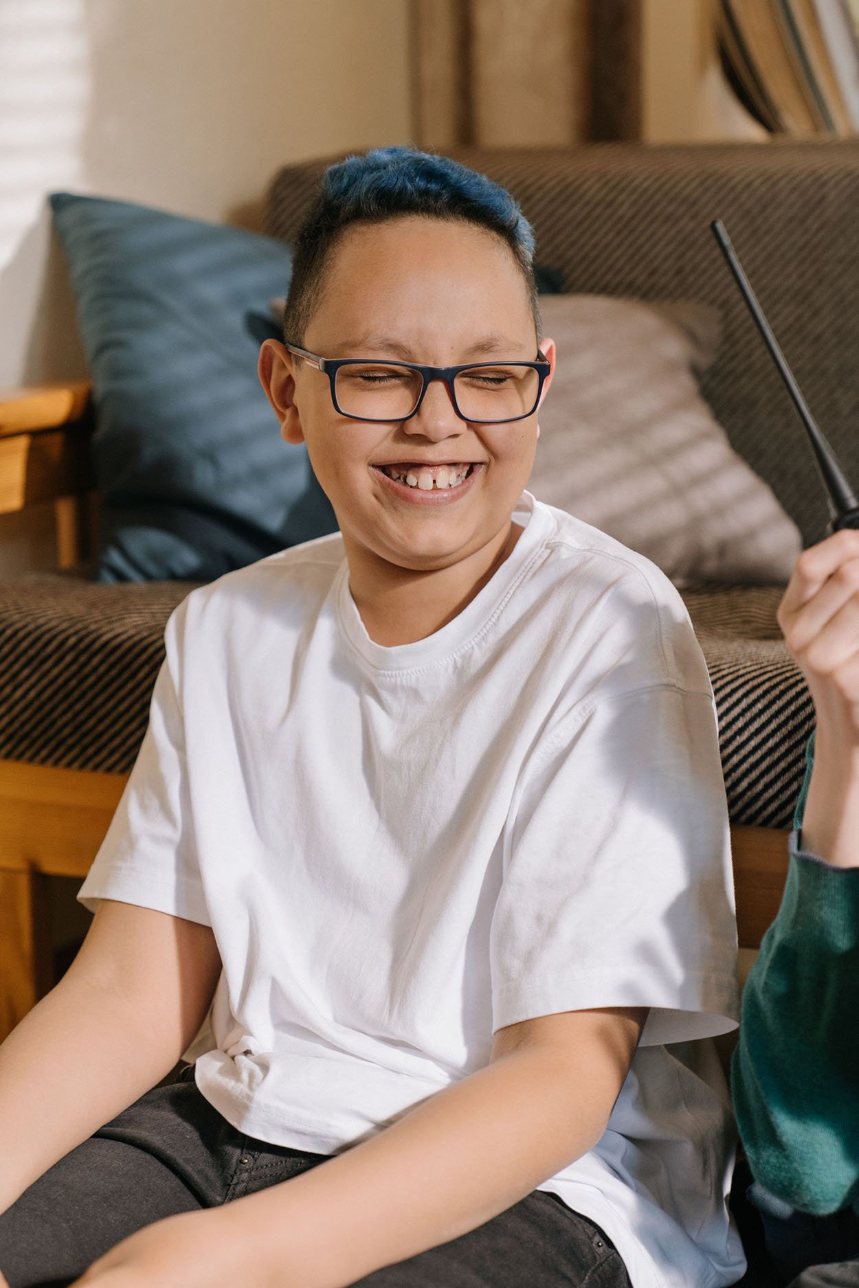 Young D&D player smiling while sitting on the floor.
