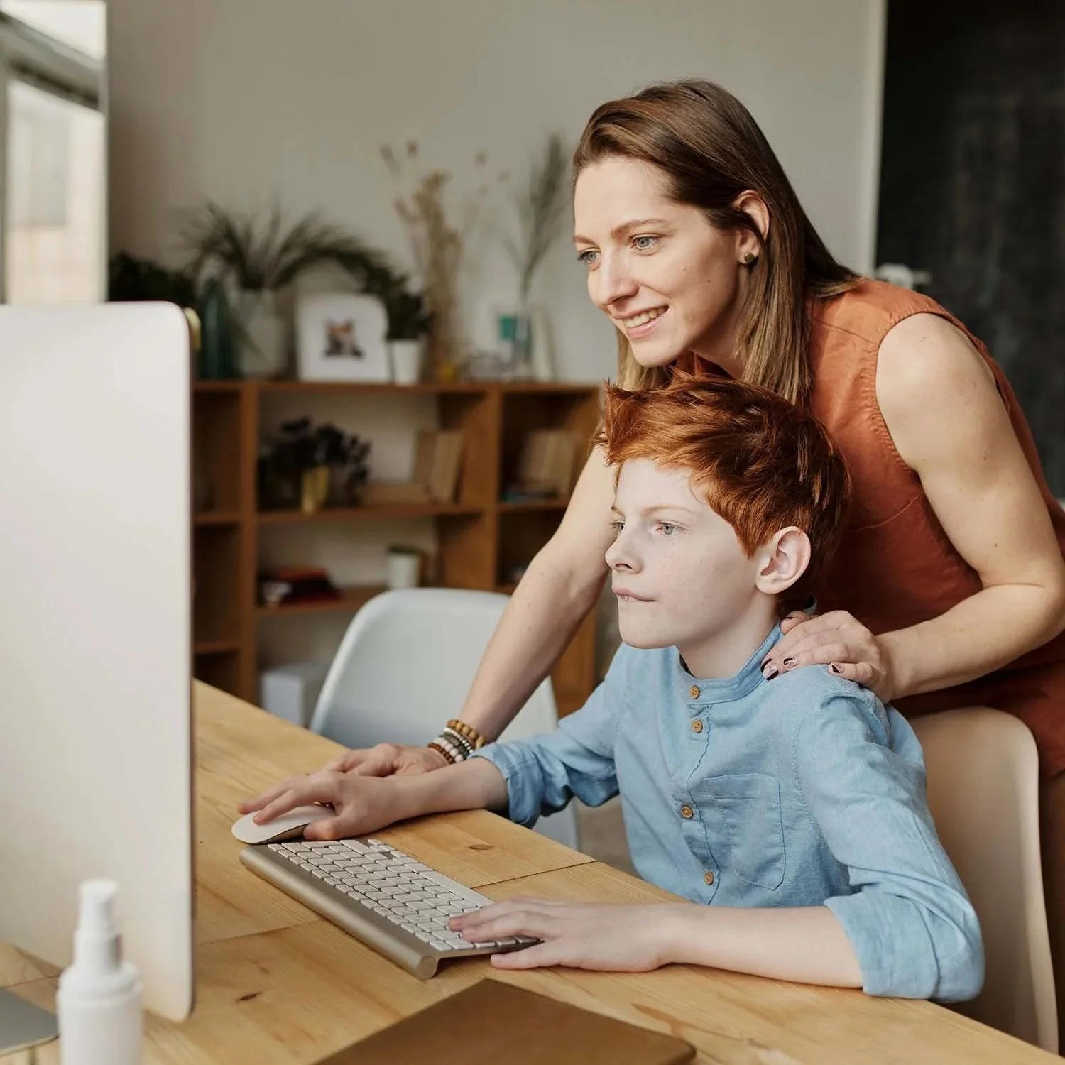 Mom and son pre-register for an online D&D group together on a computer.