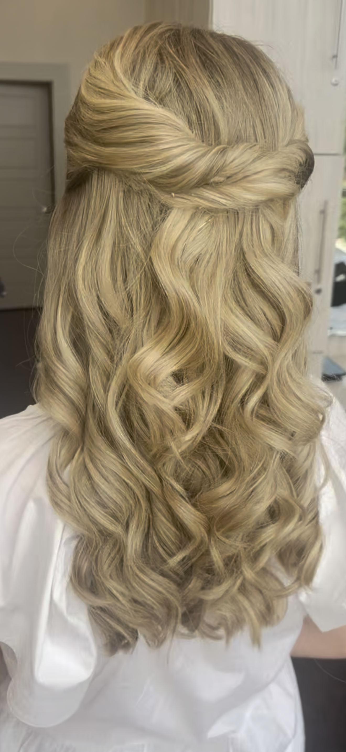 Blonde woman with long, wavy hair styled with a twisted crown braid.