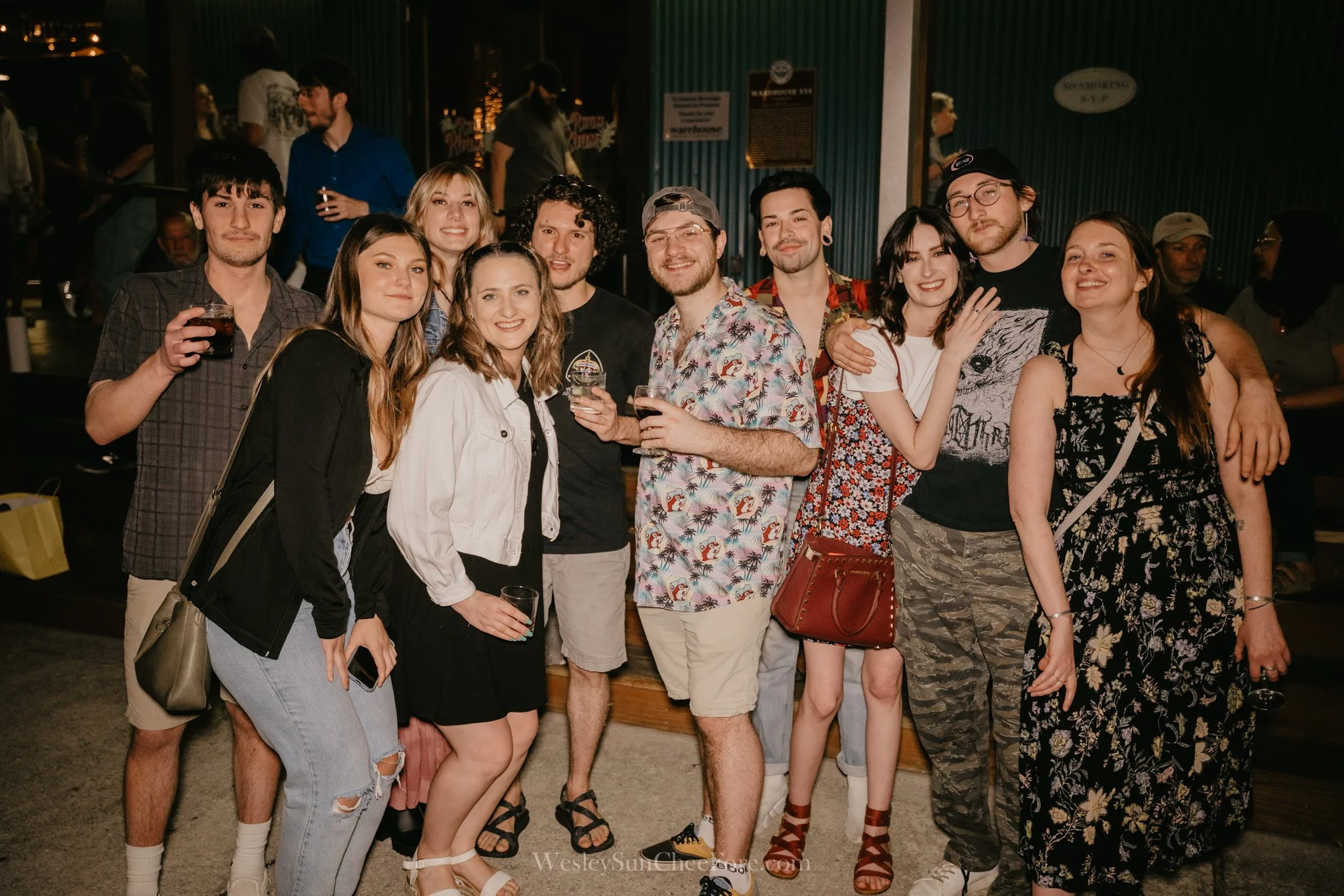A group of friends gathered together, smiling and posing for a photo at a social event or party.