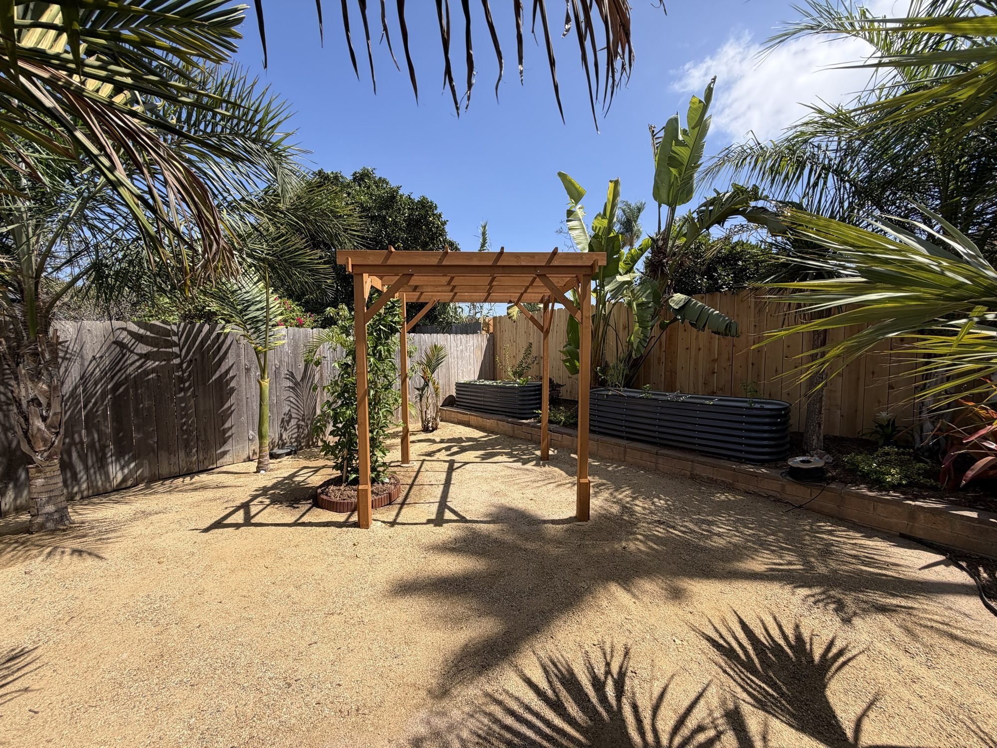 San Diego backyard edible garden with decomposed granite paths, a cedar pergola and corrugated-metal raised vegetable beds