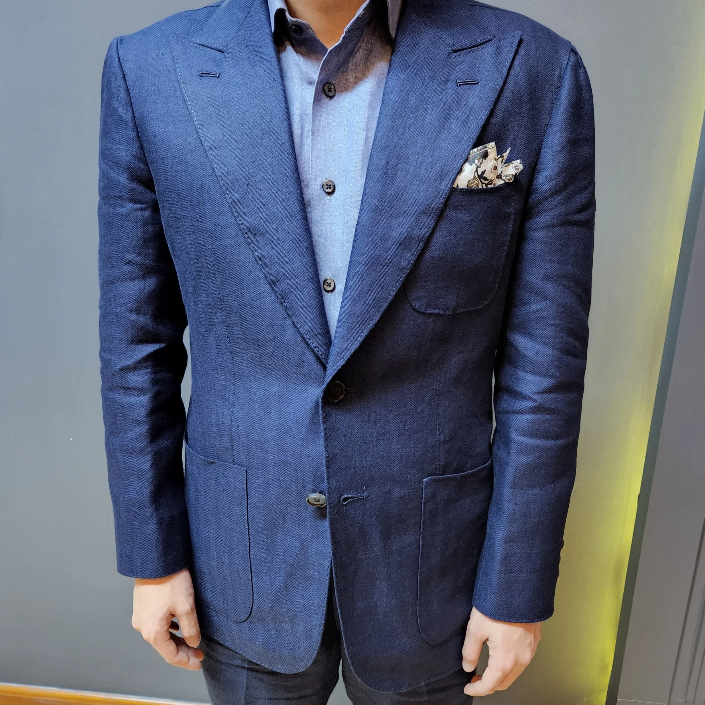 A Sein Shwe tailor wearing a bespoke navy blue suit with a complementing light blue shirt