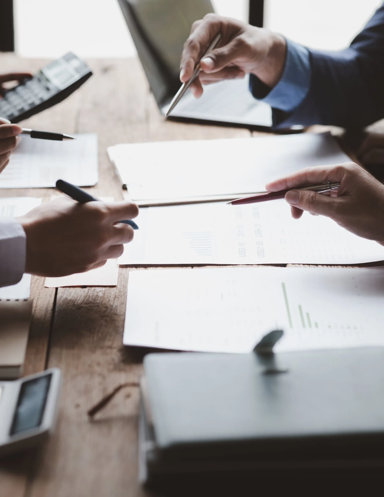 Business professionals reviewing charts and reports during a data analysis meeting, illustrating how Excel statistics support marketing performance analysis and data-driven business decisions.