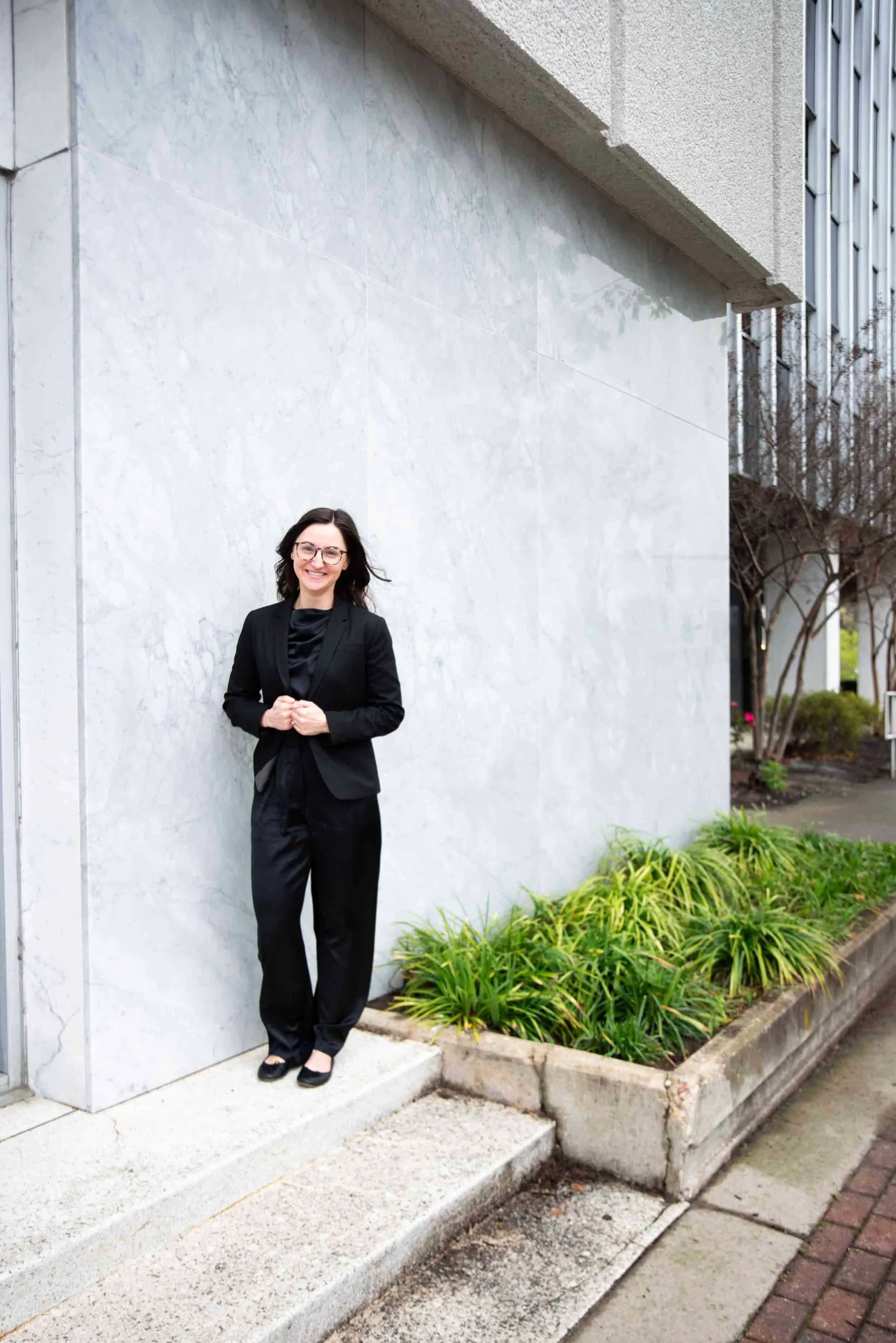 Power BI consulting and DAX dashboard development help businesses simplify complex data, improve reporting clarity, and make data-driven decisions, illustrated by a modern architectural building with Kristin Dain standing outside.