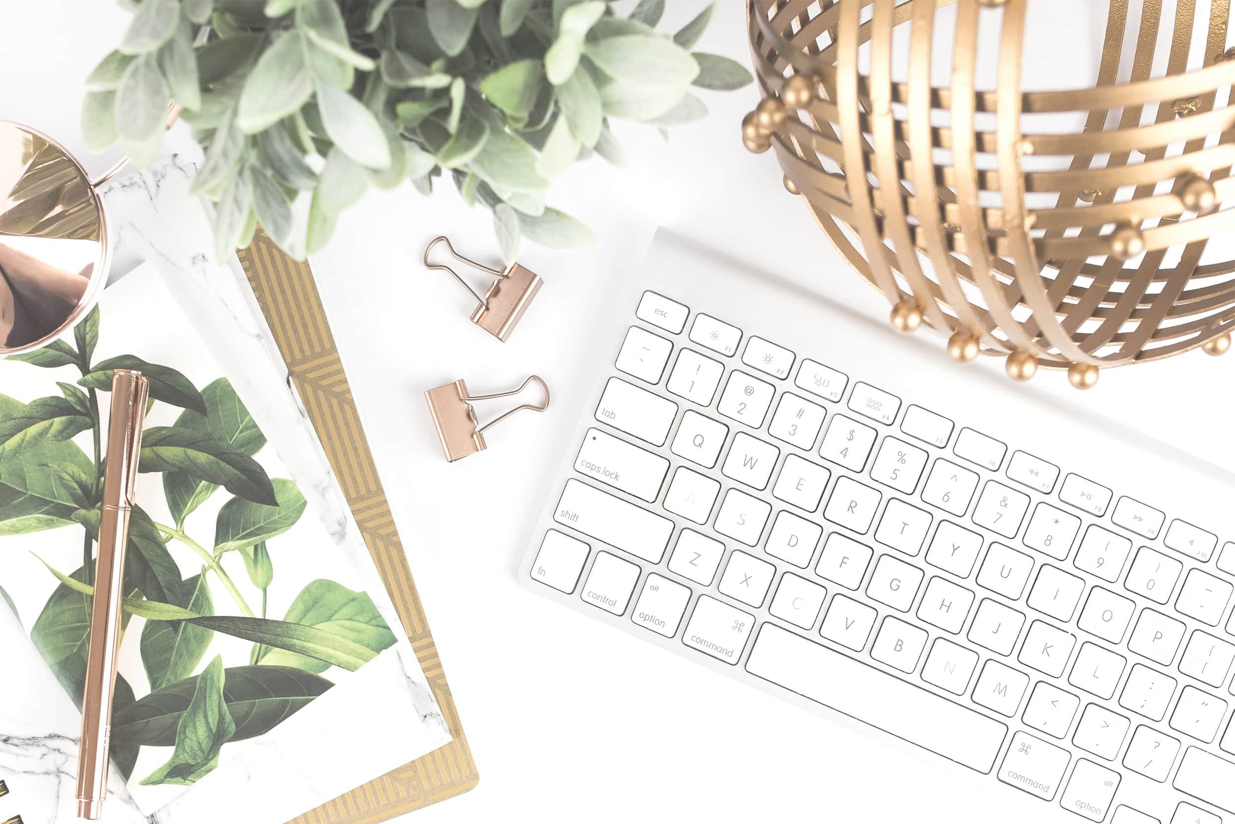 Influencer marketing analytics helps businesses assess campaign effectiveness and sales outcomes, represented by a white keyboard, green plants, and gold desk accessories.