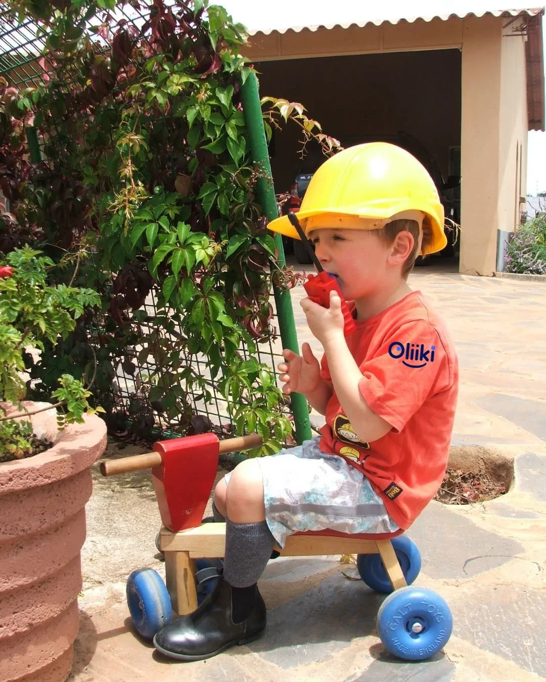 Boy on bike with hard hat and play walkie talkie