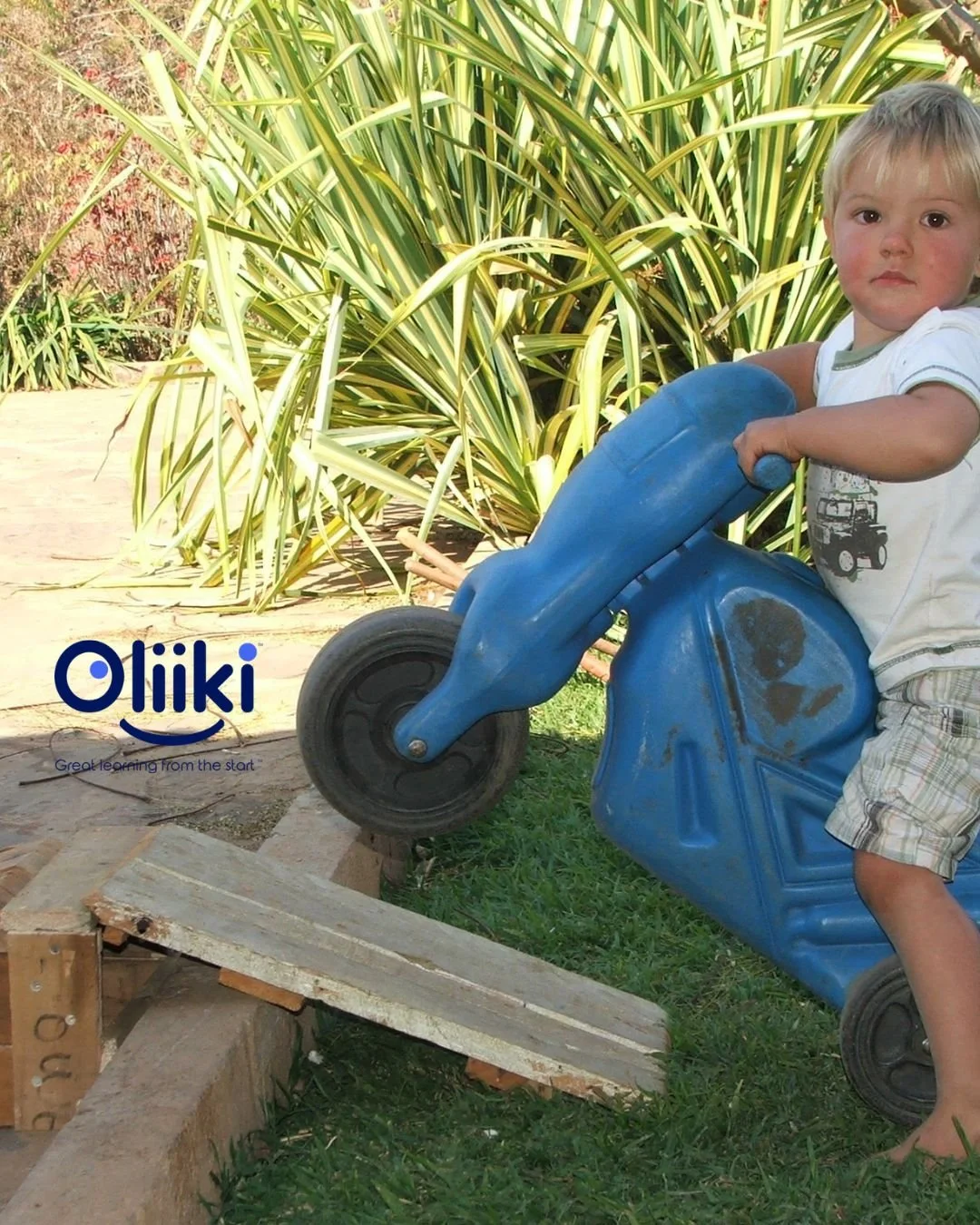 Young boy on plastic motorbike on a ramp