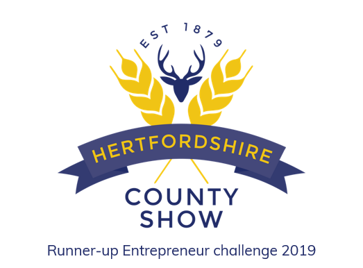 Logo of Hertfordshire County Show featuring a deer head, wheat sheaves, and text, "Est 1879. Runner-up Entrepreneur Challenge 2019."