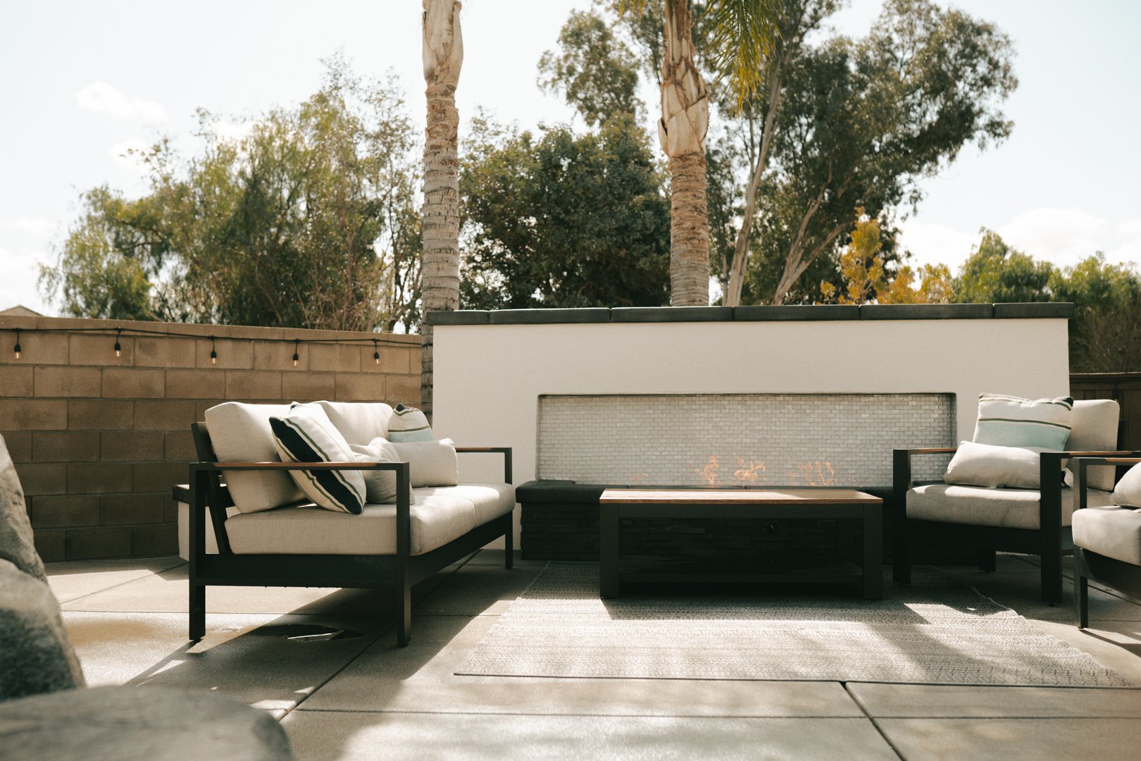 Lounge area in a home backyard including a fire pit designed and built by Element Pools & Spas