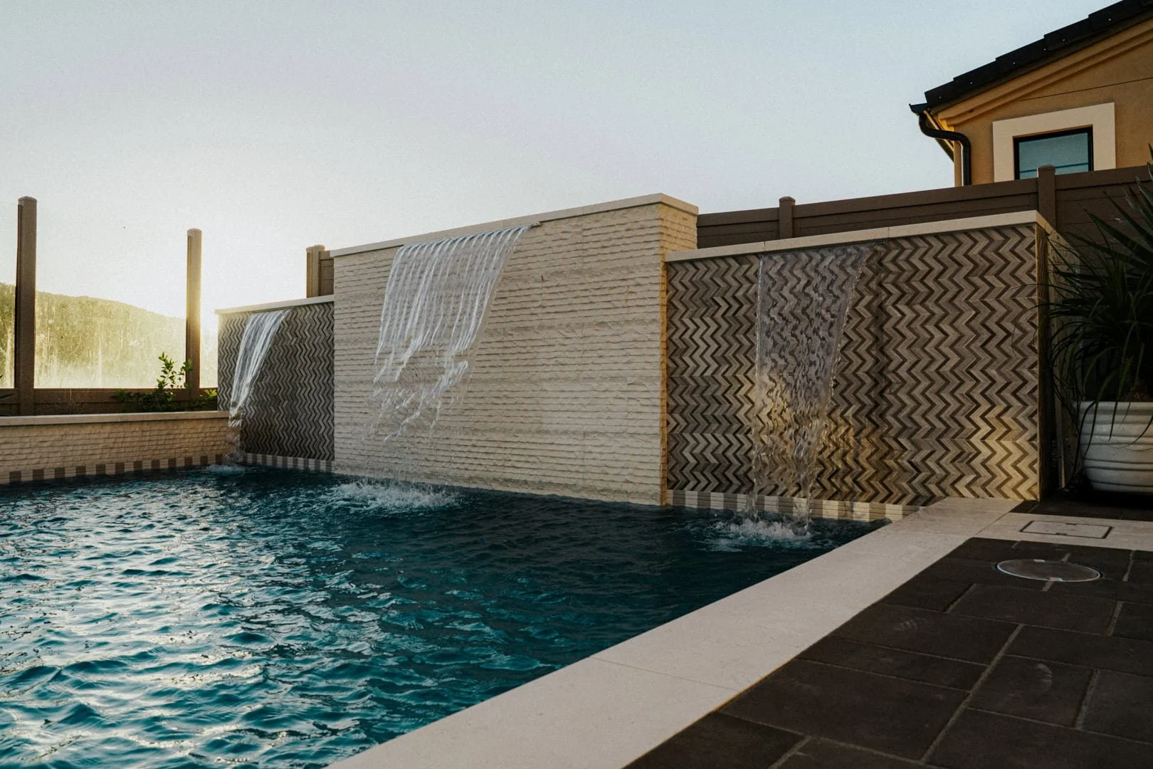 Custom swimming pool with waterfall sunset in background 2.jpg