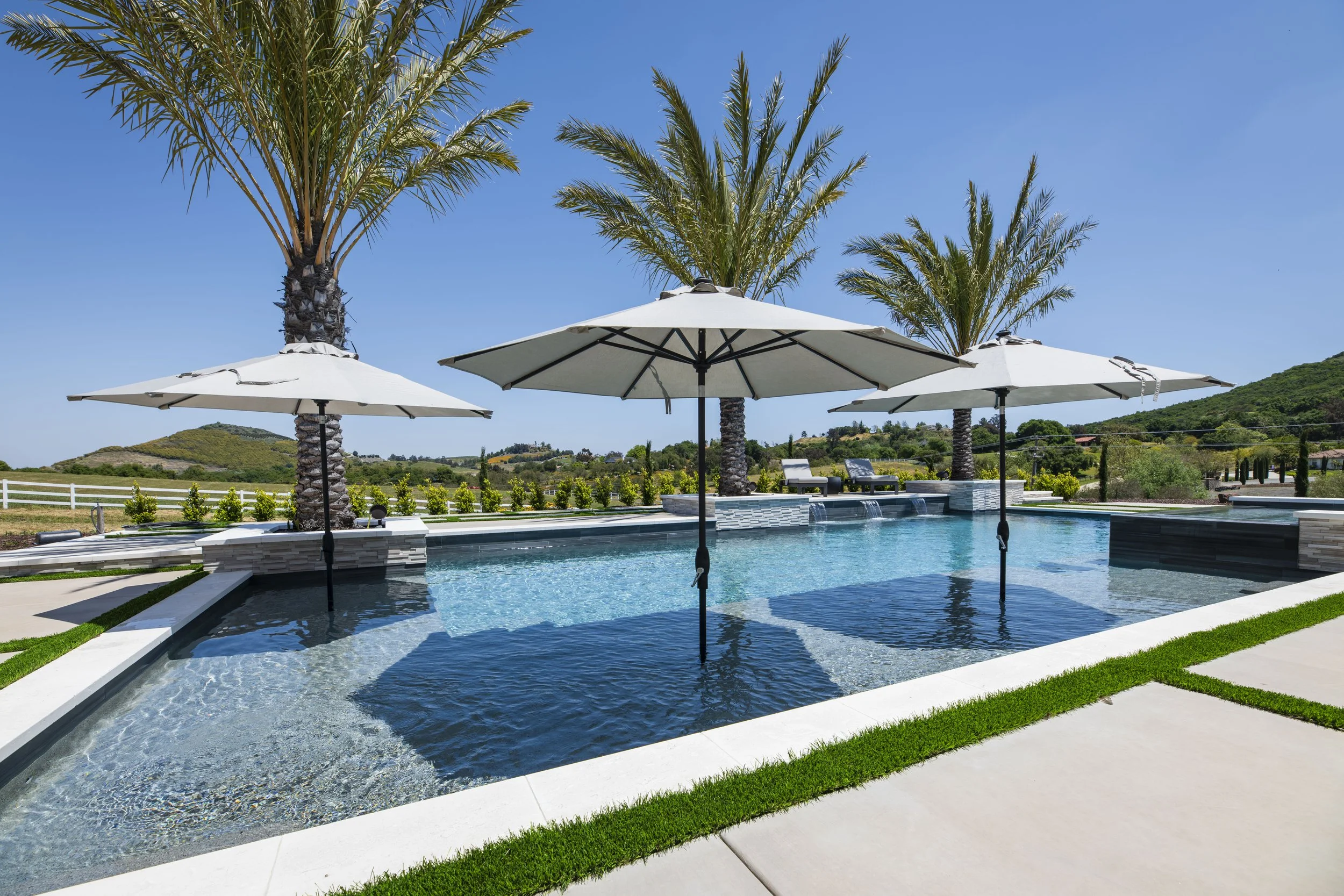Custom pool with tanning ledge, built-in umbrellas, and spa
