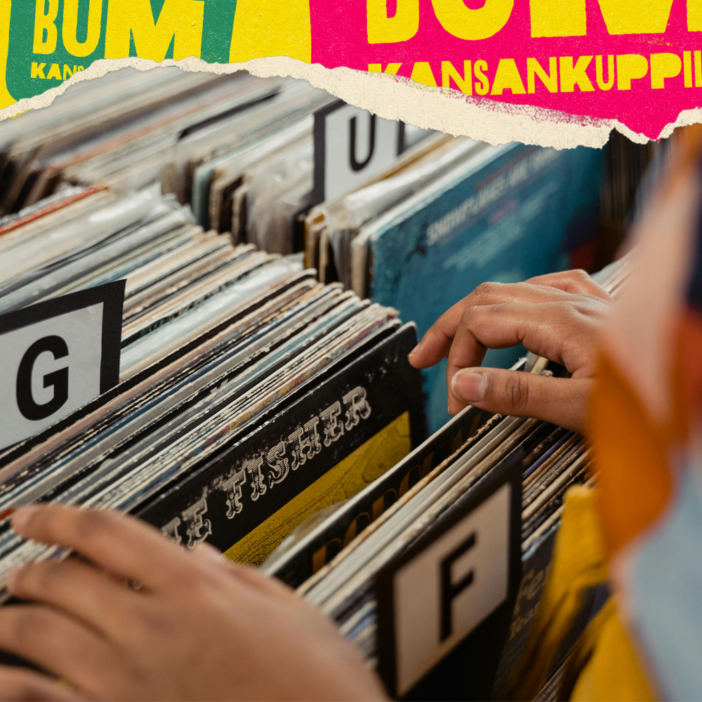 Kuvassa on ihmisen käsi, joka selaa levyjä kaupan musiikkiosastolla, ja taustalla värikkäitä julisteita.