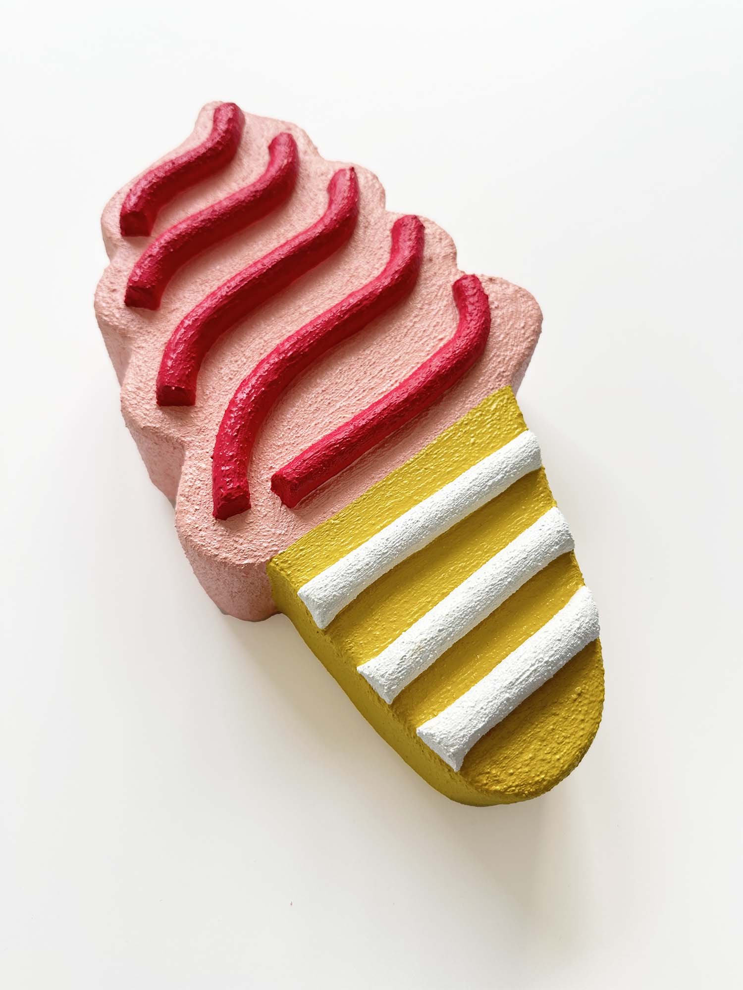 Side view of light pink and mustard ice cream sculpture by Steph Blondet, showing textured sculptural detail