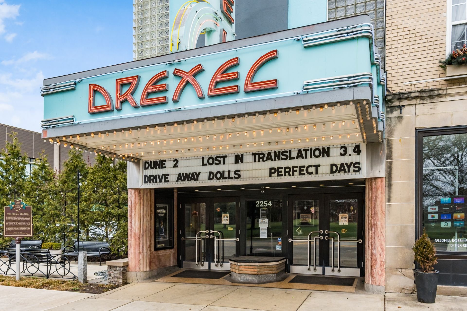 Entrance of the Drexel Theatre with marquee displaying movie titles.