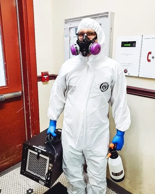 Biohazard cleaner using disinfectant equipment in a hospital corridor.