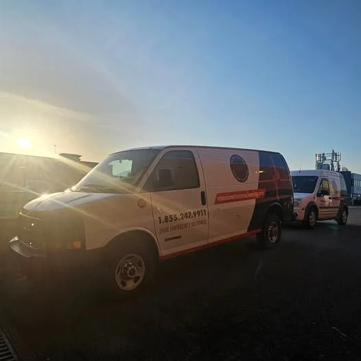 Emergency response vans parked outdoors during sunset, with a clear sky in the background.