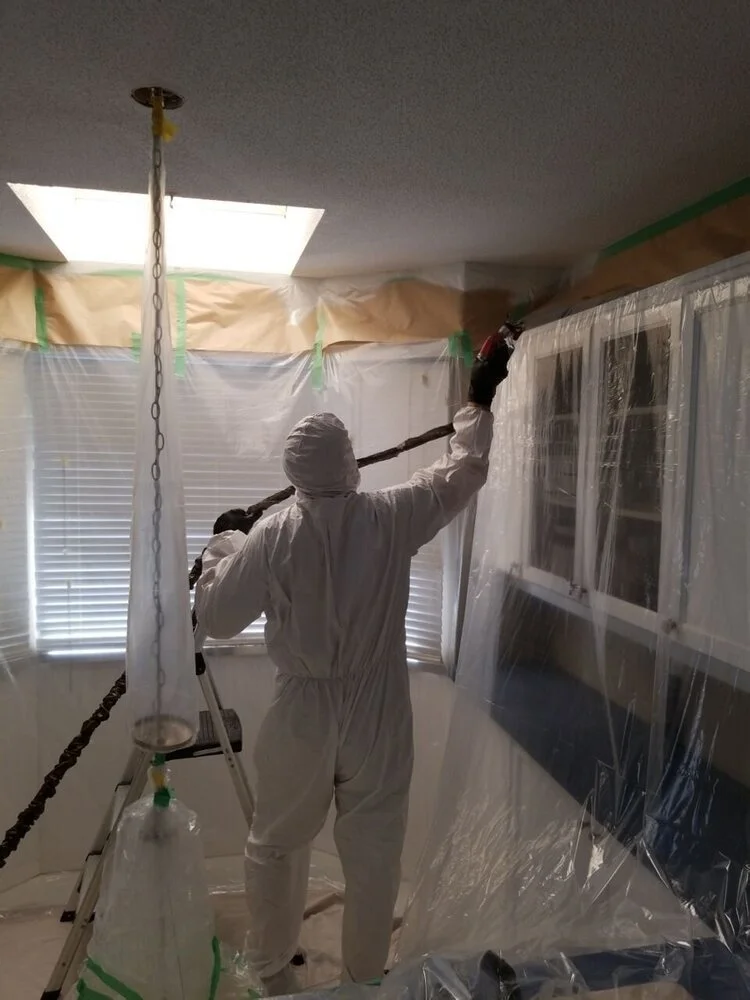 Hazardous materials cleaner conducting work in a fully contained room.