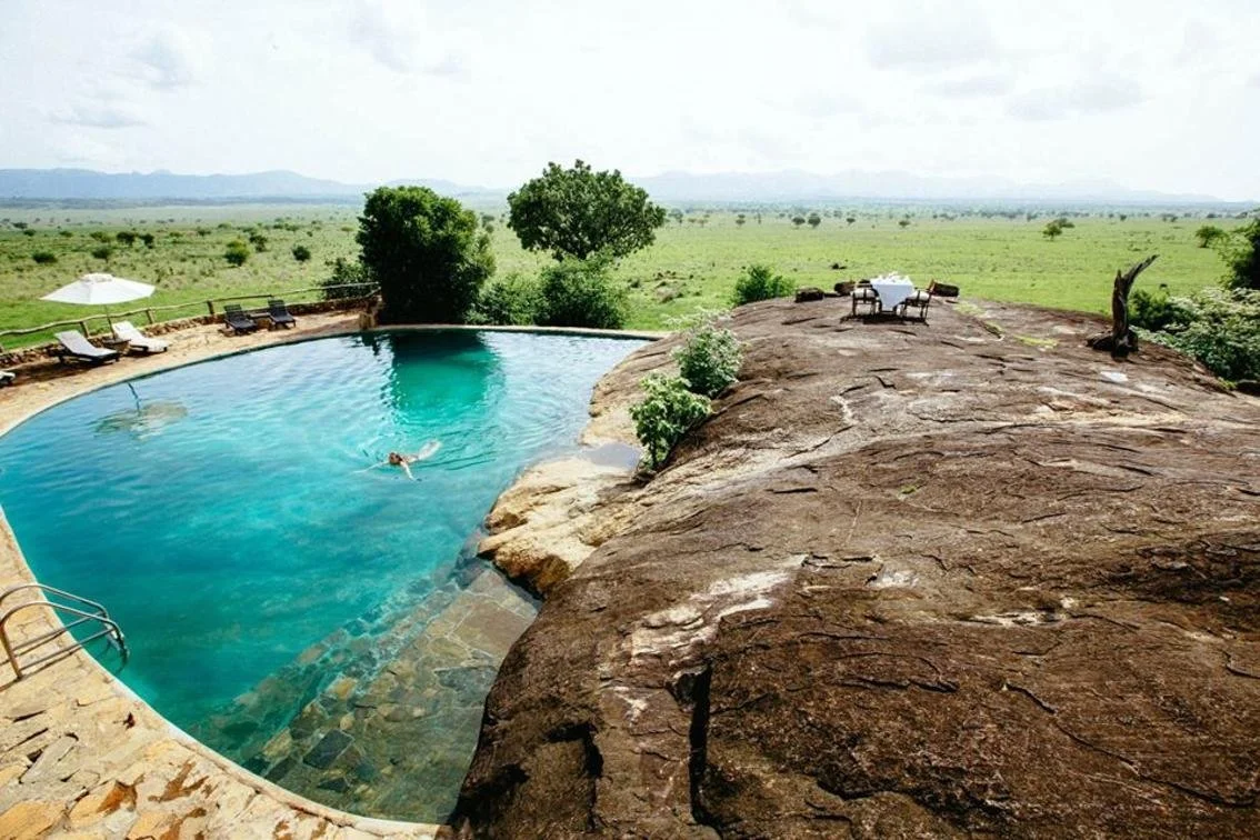 Infinity-edge rock pool overlooking vast African plains, included in many luxury safari packages for ultimate relaxation.