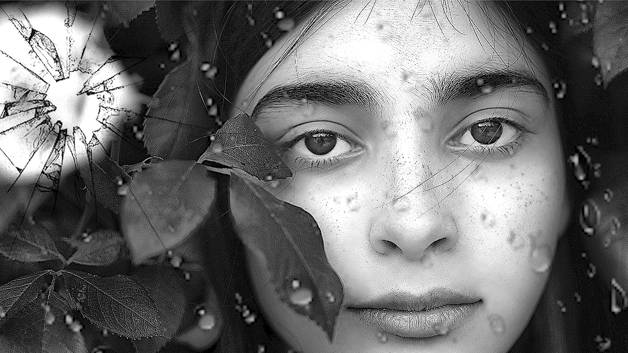 Close-up of a woman's face framed by leaves and water droplets, with a cracked glass effect on the left side of the image.