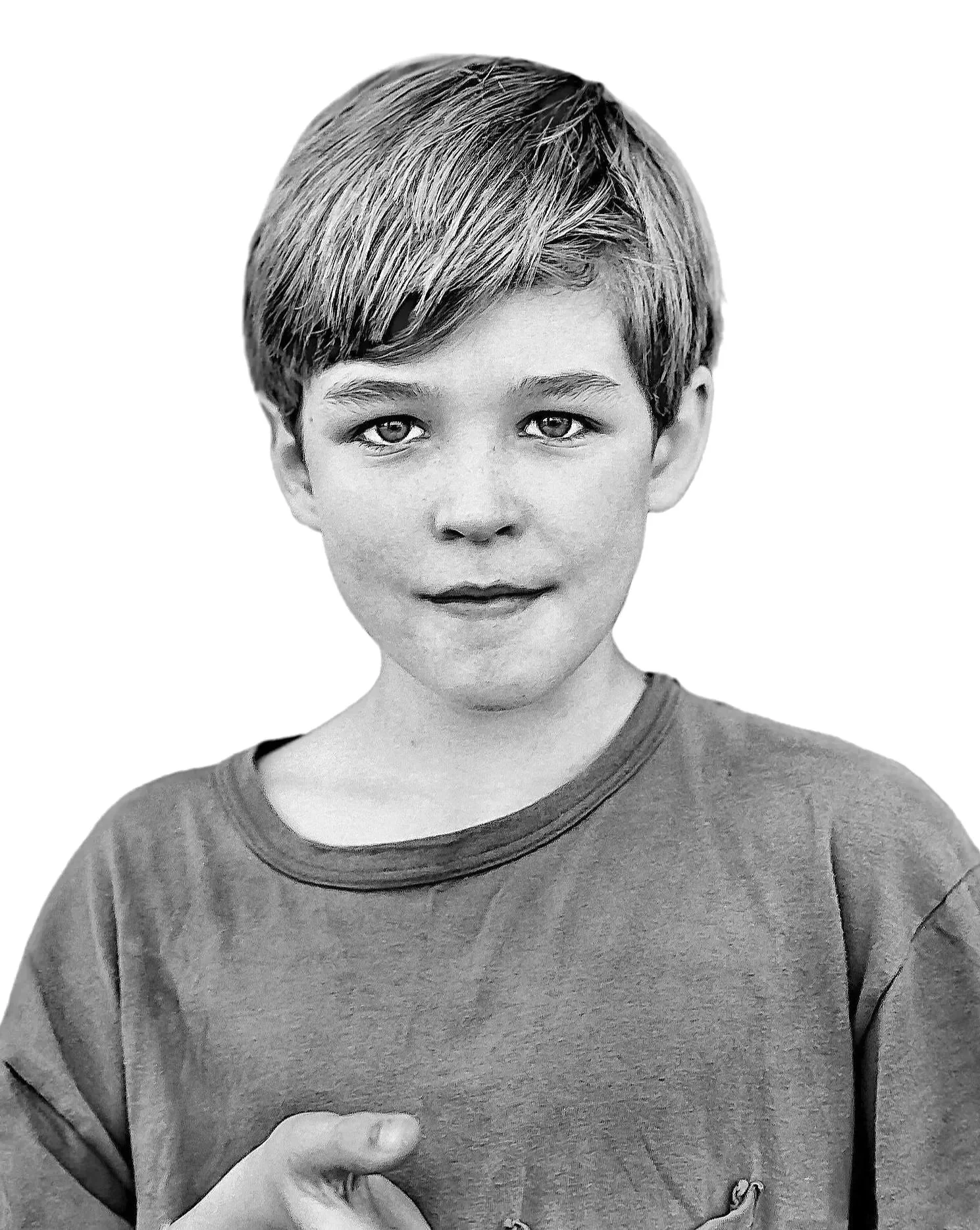 Black and white photo of a young boy with short hair, wearing a T-shirt, pointing with his finger.