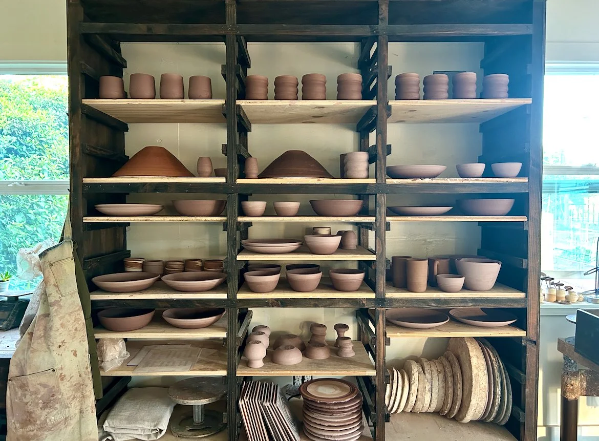 Shelves filled with handmade stoneware bowls, mugs, plates and serving pieces inside the Hayes Ceramics pottery studio in Sonoma County, California.