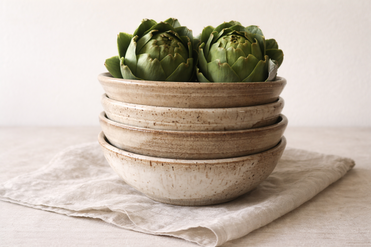 handmade stoneware bowls stacked with fresh artichokes by Hayes Ceramics