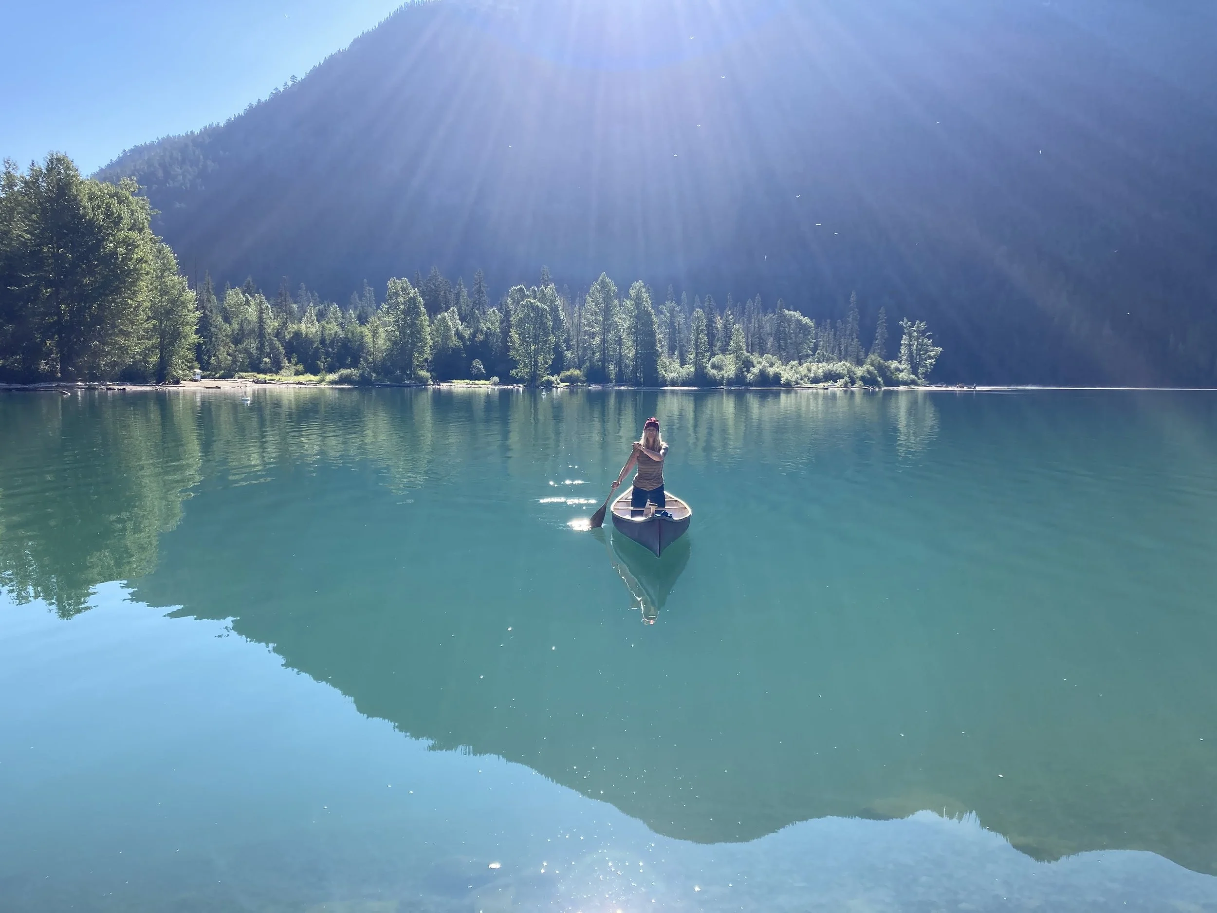 Jullie Crandlemire, low cost intern therapist, canoeing on a lake in the mountains