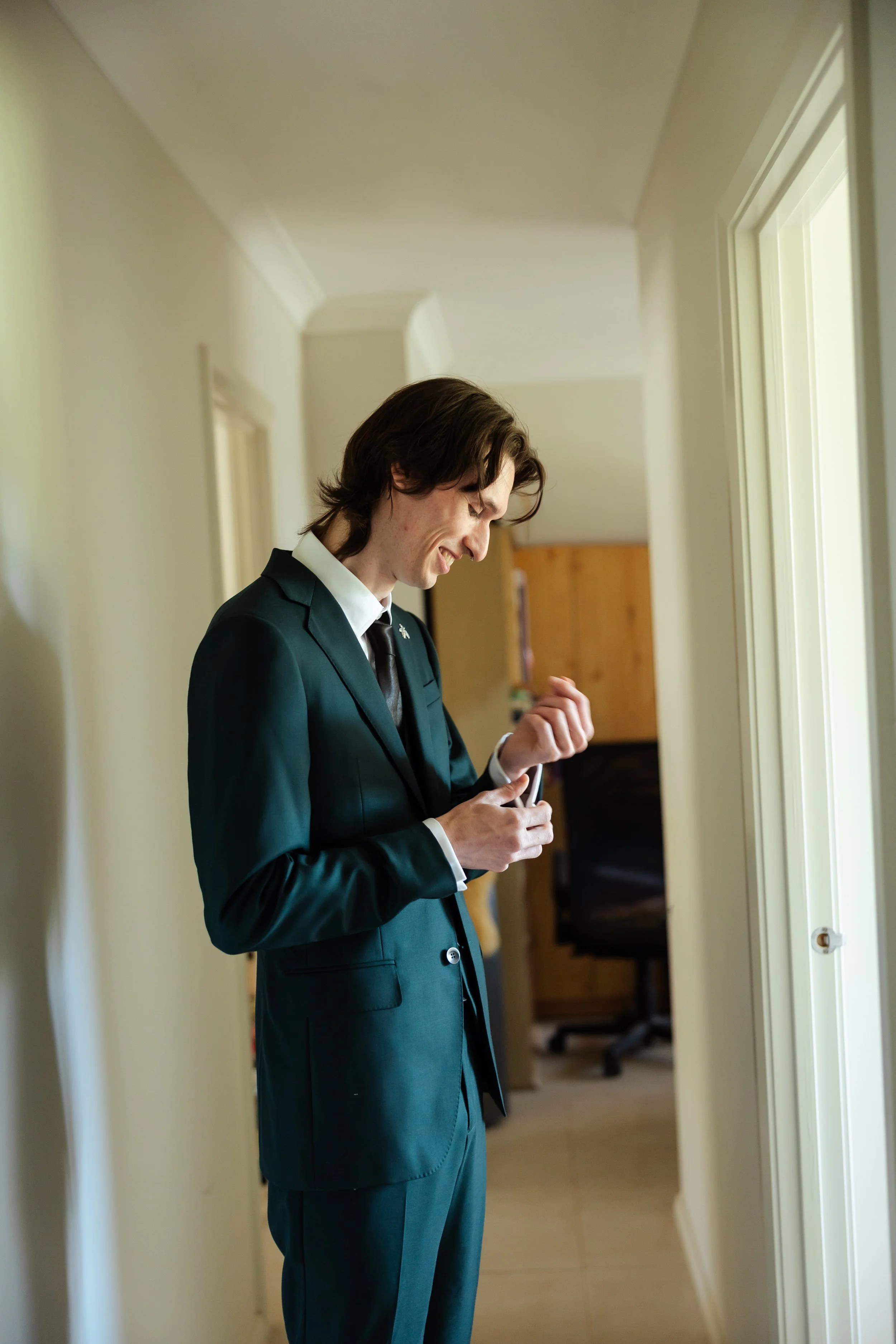hallway photo of man getting dressed for wedding