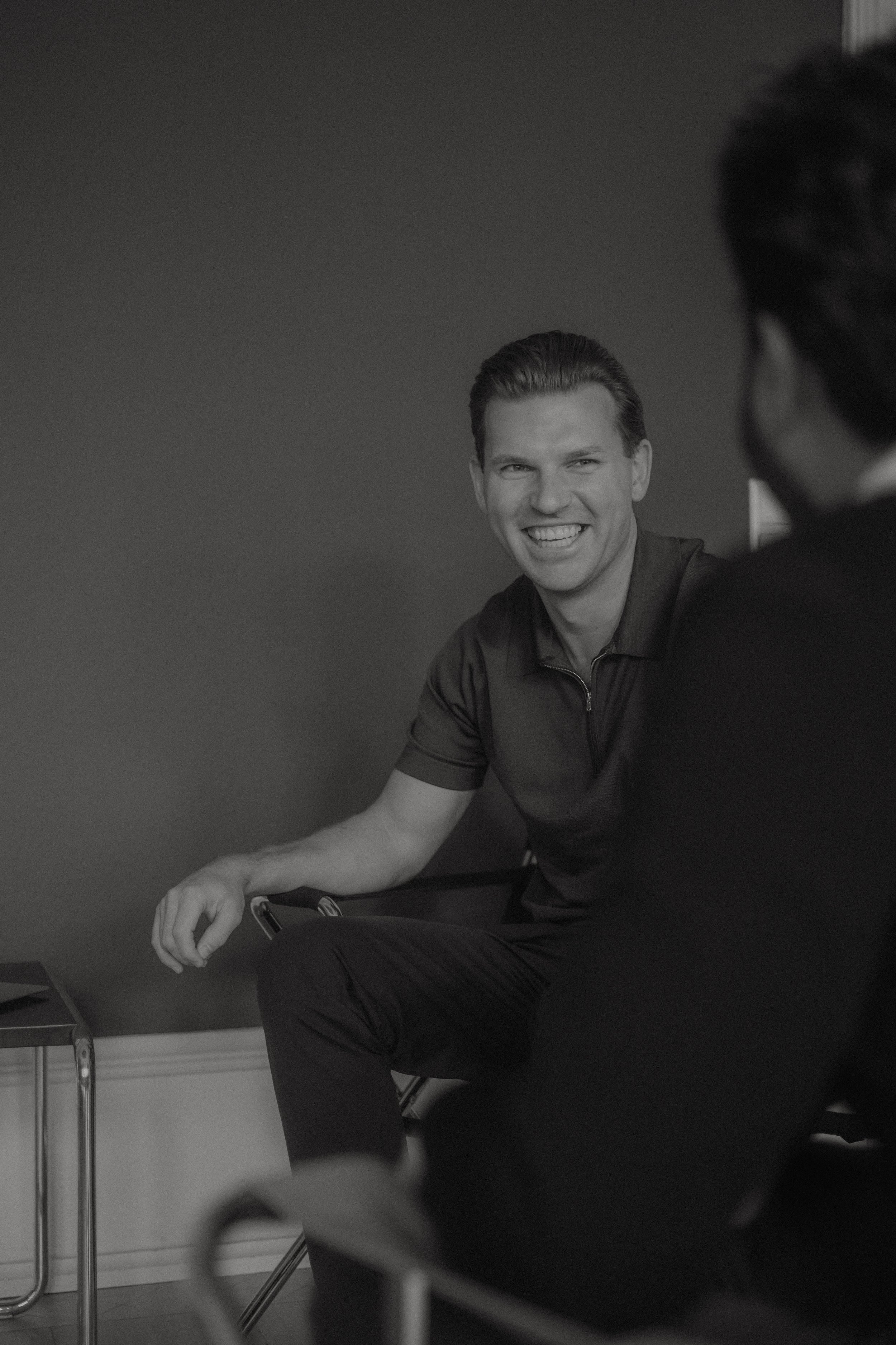 LJ & Partner I Lars Jurischka facing camera consulting a client with their back to camera black and white