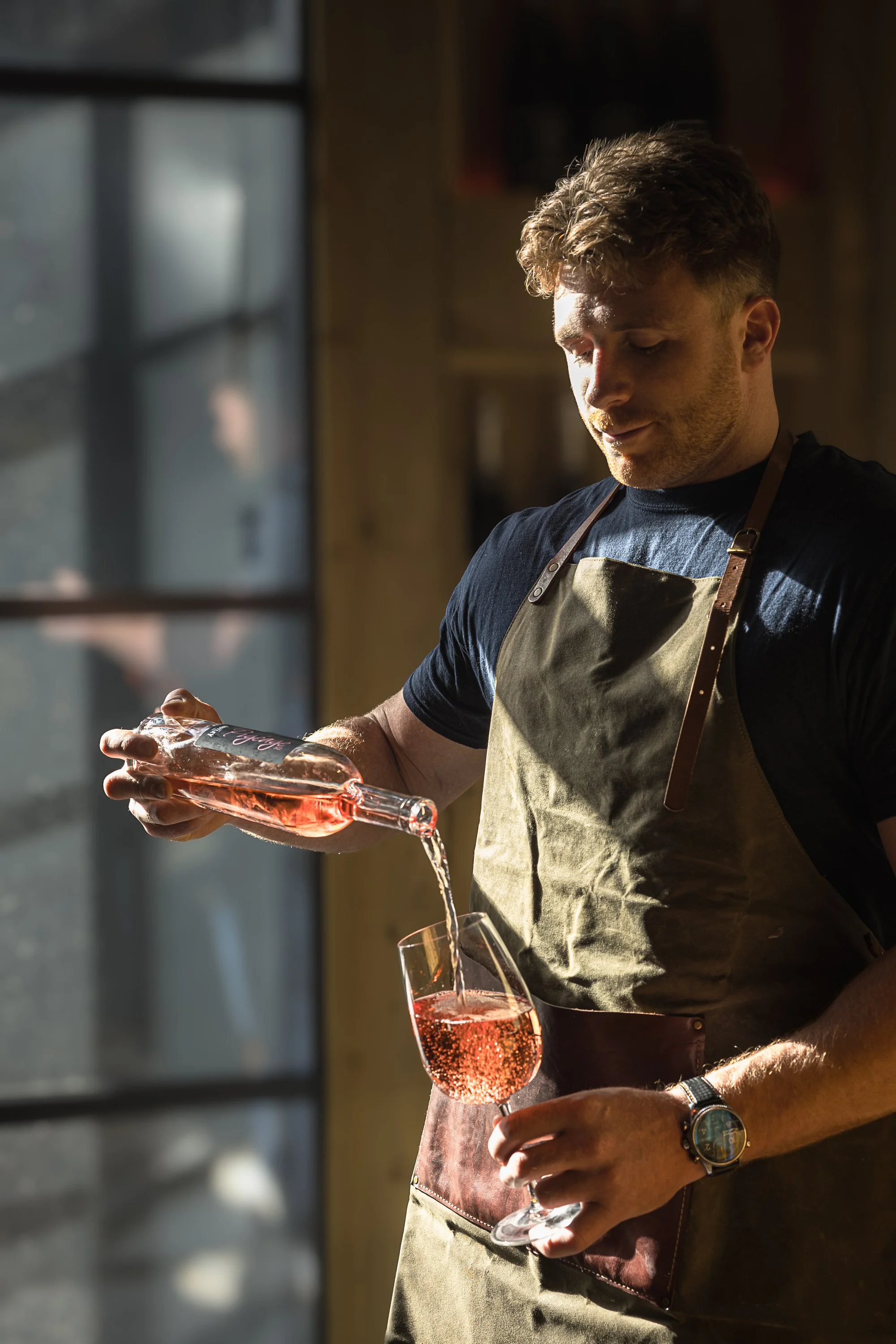 Kenton Park Estate team member pouring rosé from a glass  during a wine tasting, photographed near Exeter for hospitality, menus and promotional use.