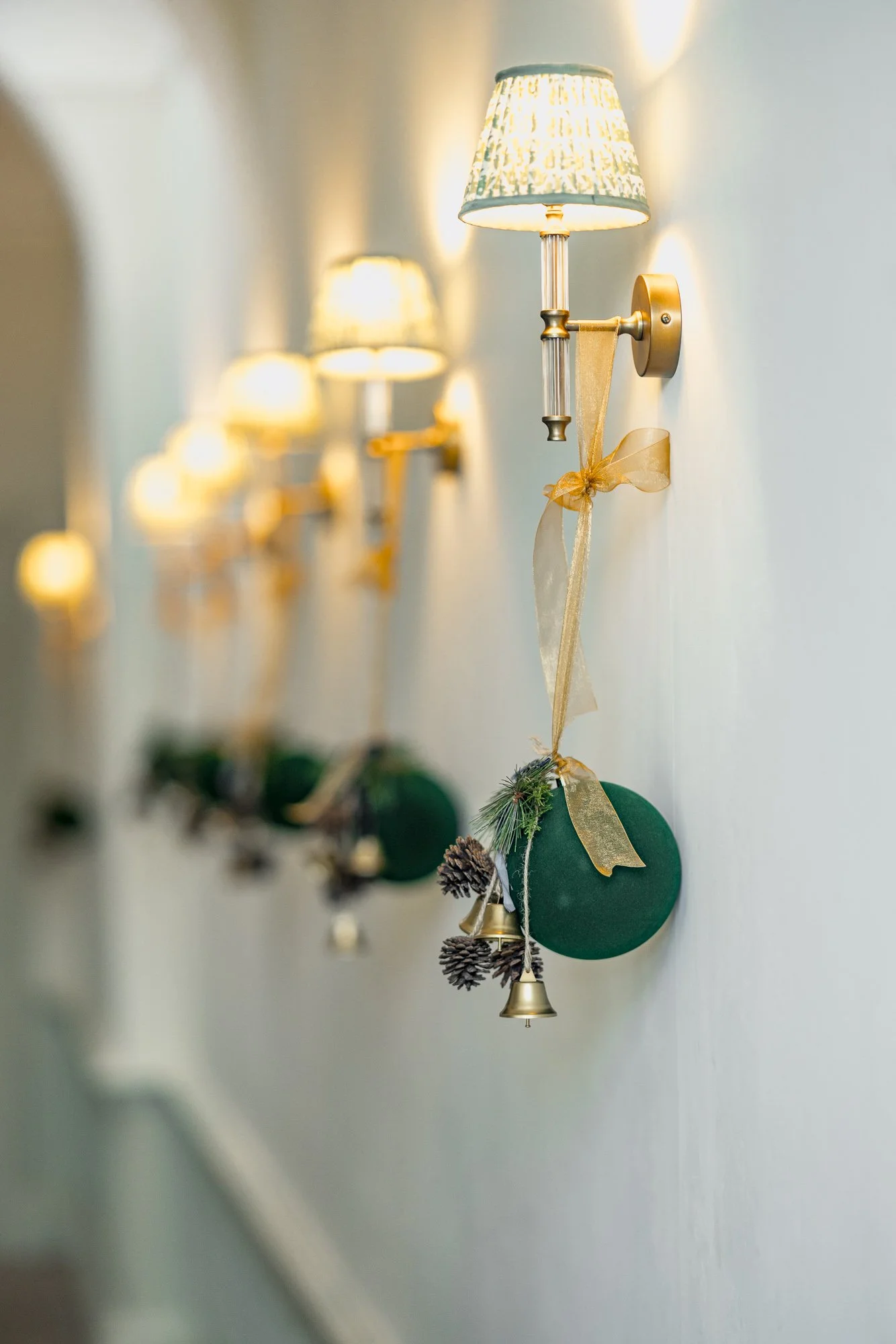 Commercial interior detail at Mount Somerset in Taunton, showing a pale corridor lined with decorative wall lamps and a small hanging Christmas decoration.
