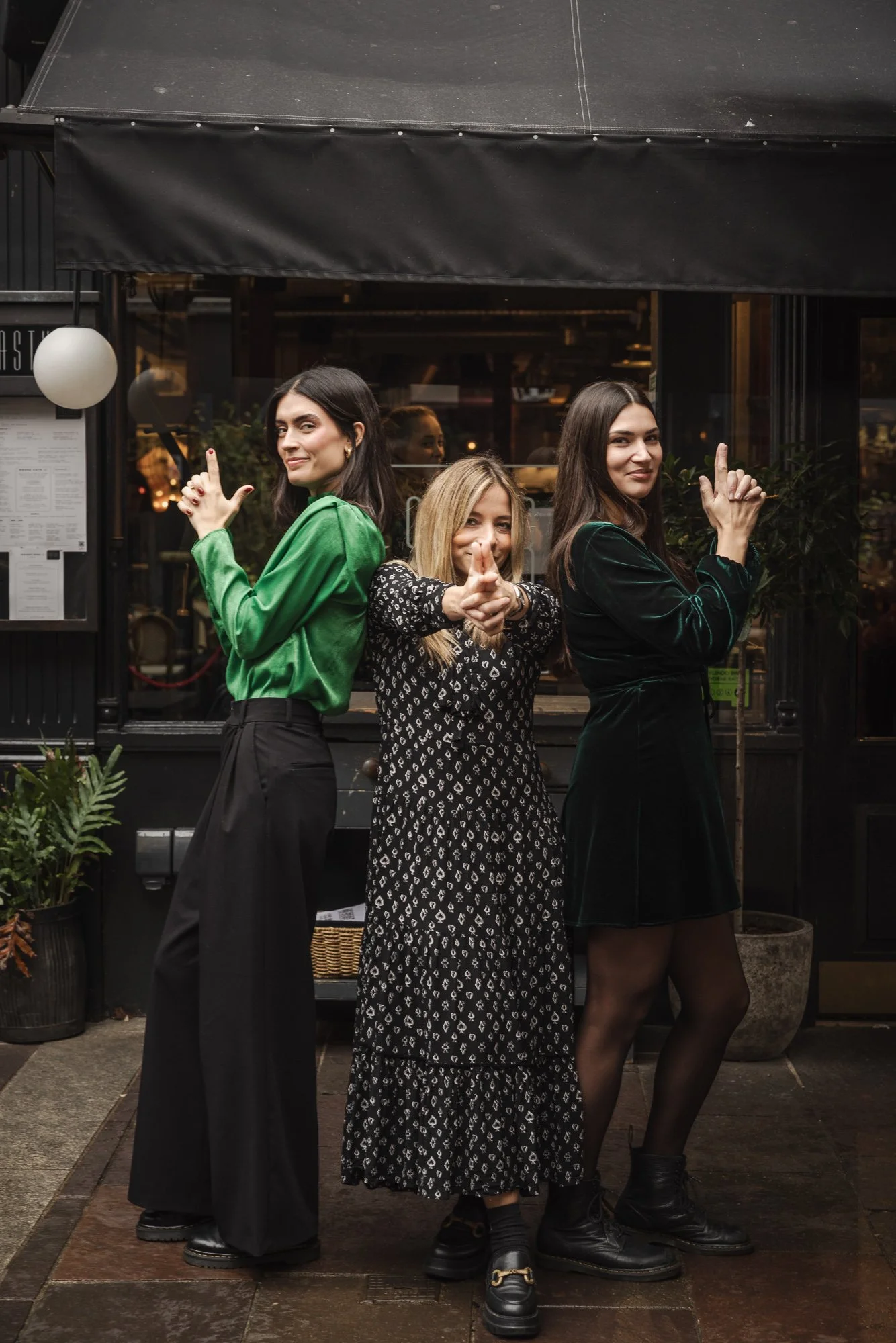 Commercial team portrait of three women standing together outside a hospitality venue with drinks in hand, using a relaxed group pose to present the personalities behind restaurant in Bristol.