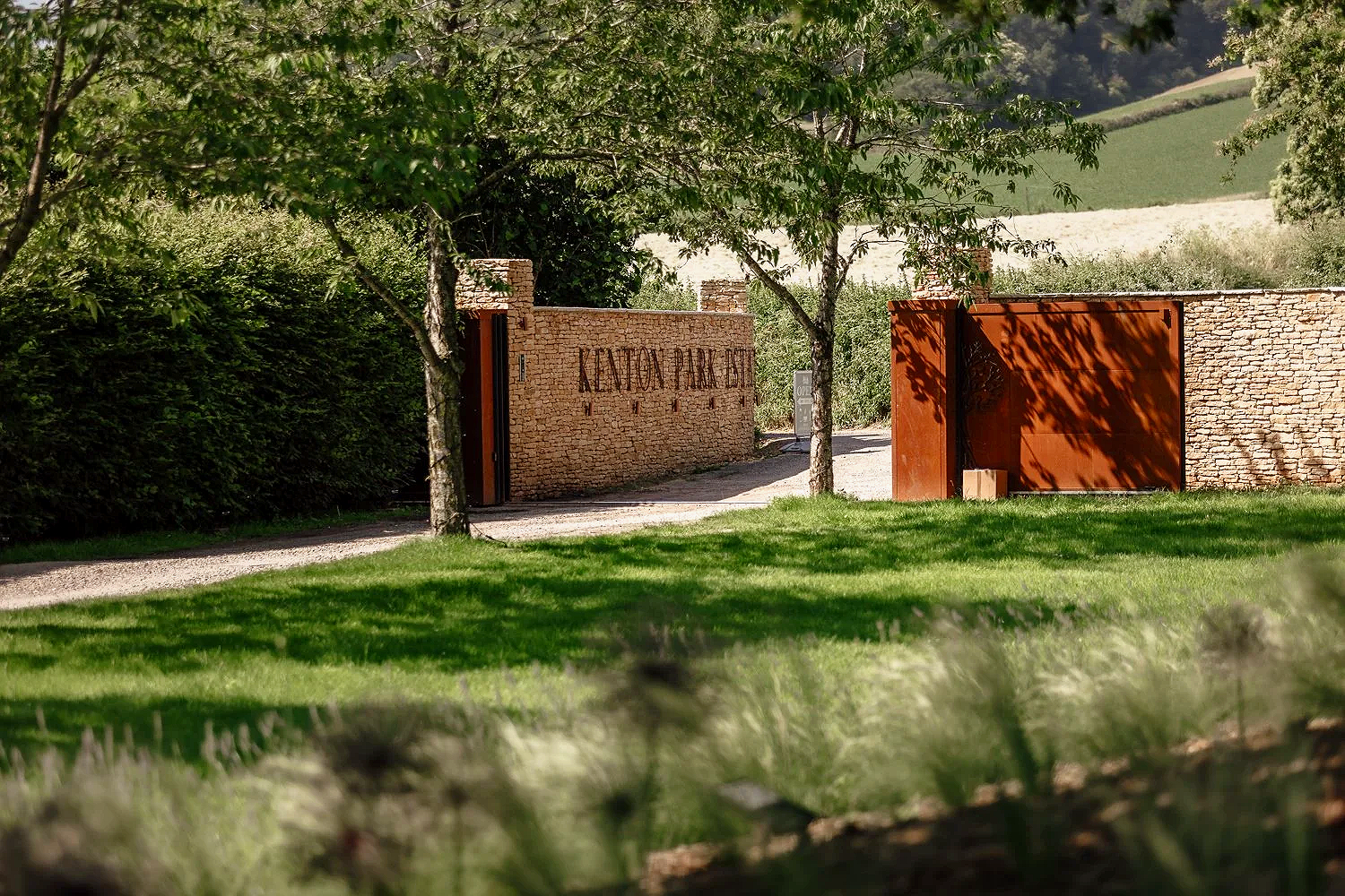 Landscaped entrance to Kenton Park Estate & Vineyard, with brick walls and rust-coloured gates, photographed near Exeter for the venue’s website and visitor marketing.