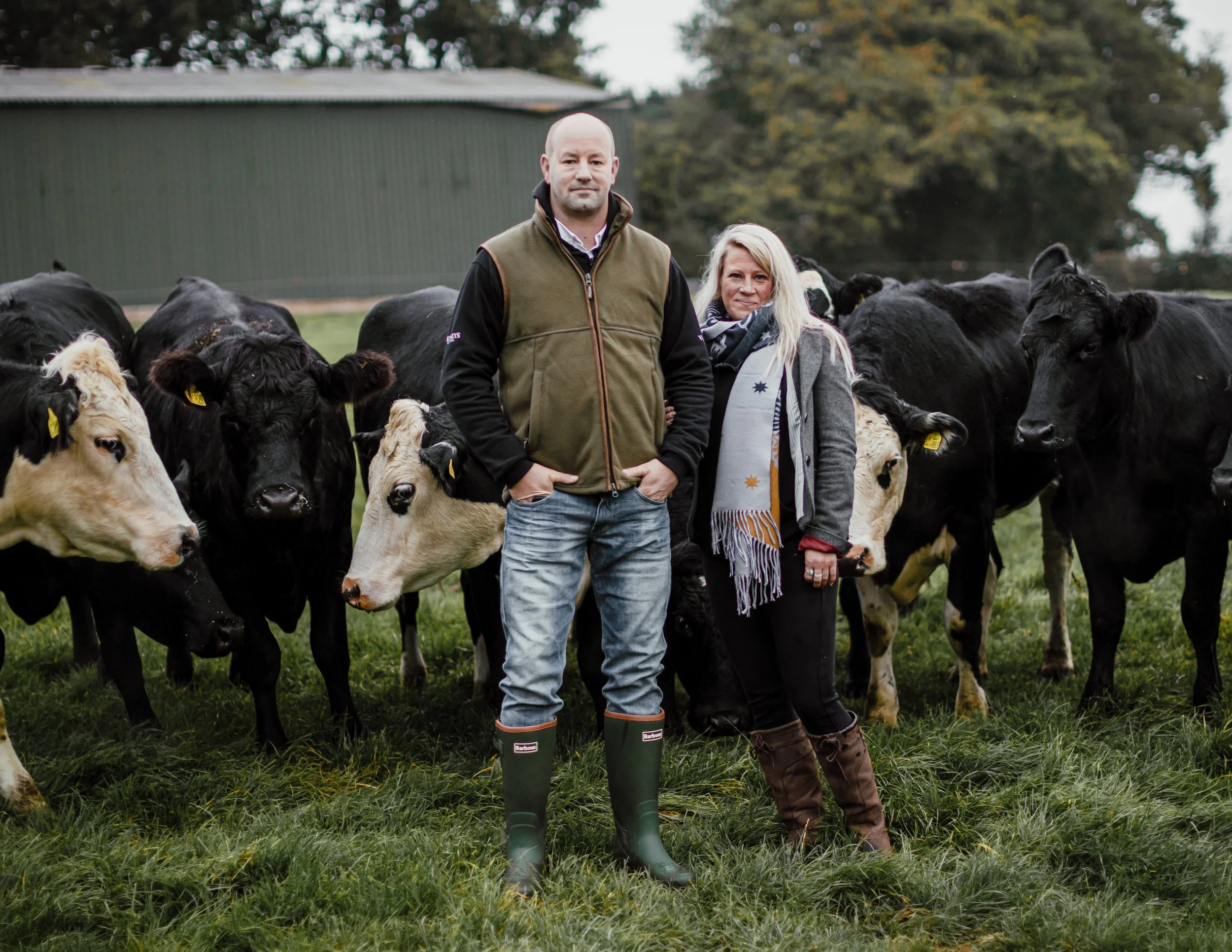 .Supplier portrait, owners with herd of cattle in field for website and PR, shot near Banbury, Oxfordshire, partnerships across Poole, Dorset, for use in London and Plymouth, Devon.
