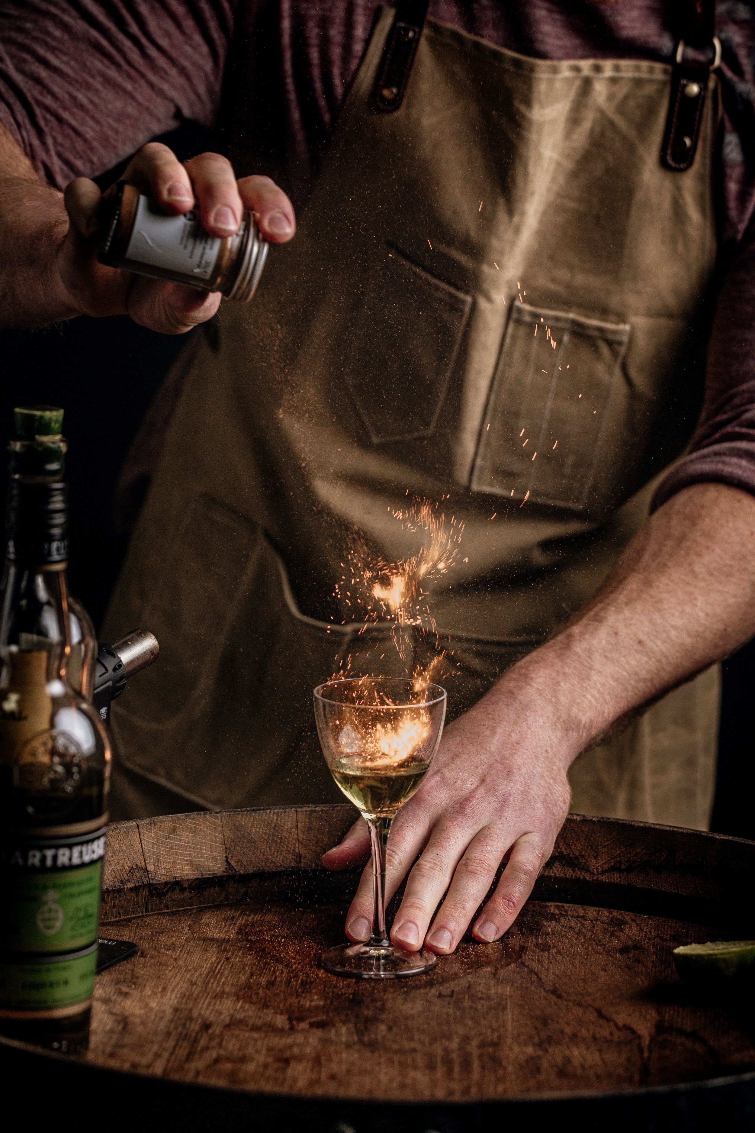 Bartender dusting cinnamon over a cocktail at Kenton Park Estate, creating a cloud above the glass for the vineyard’s drinks and hospitality imagery.