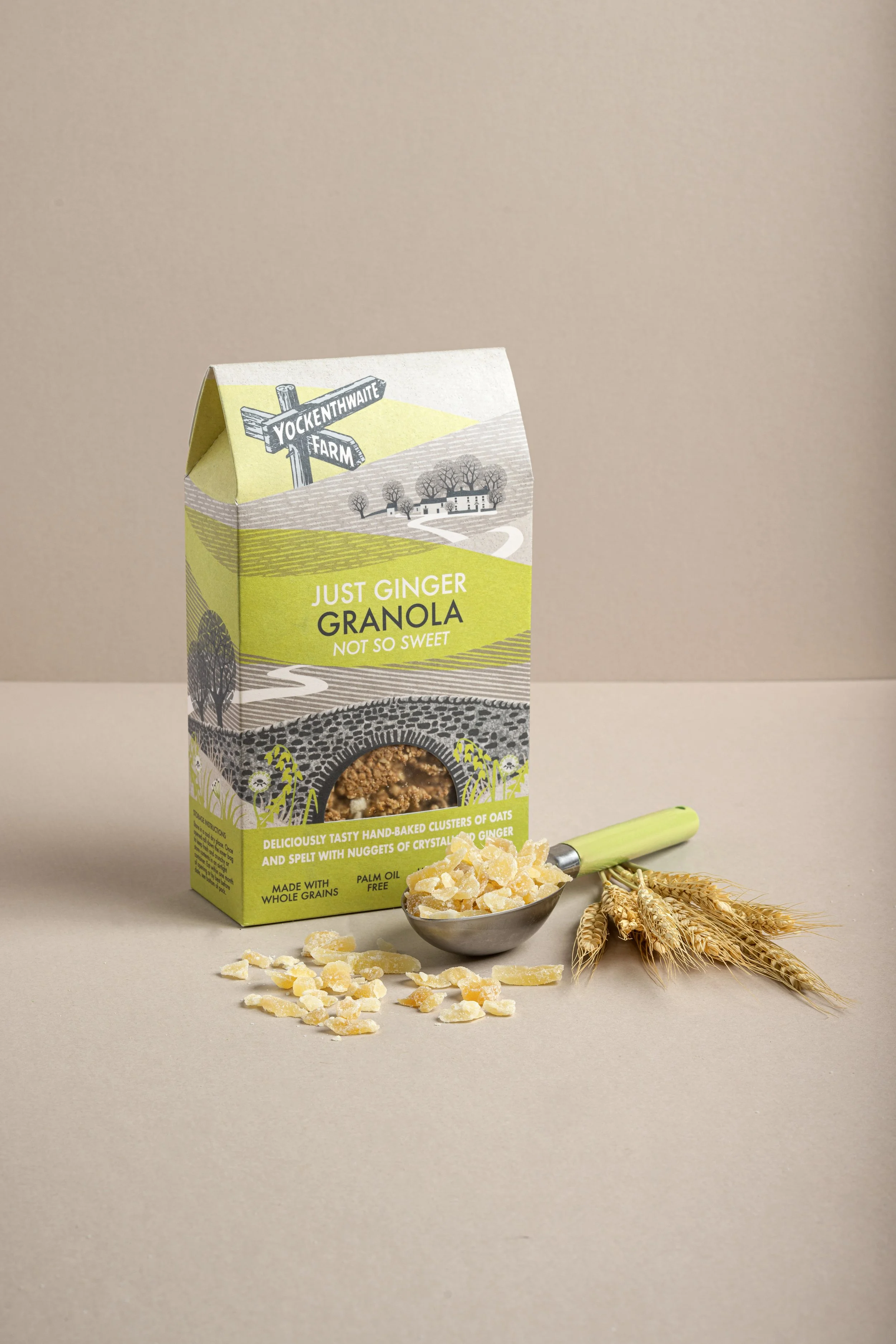 Commercial food product photograph of a standing packet of yockenthwaite  ginger granola with scattered oats and ingredients, styled against a warm neutral background to show the packaging and natural product cues.