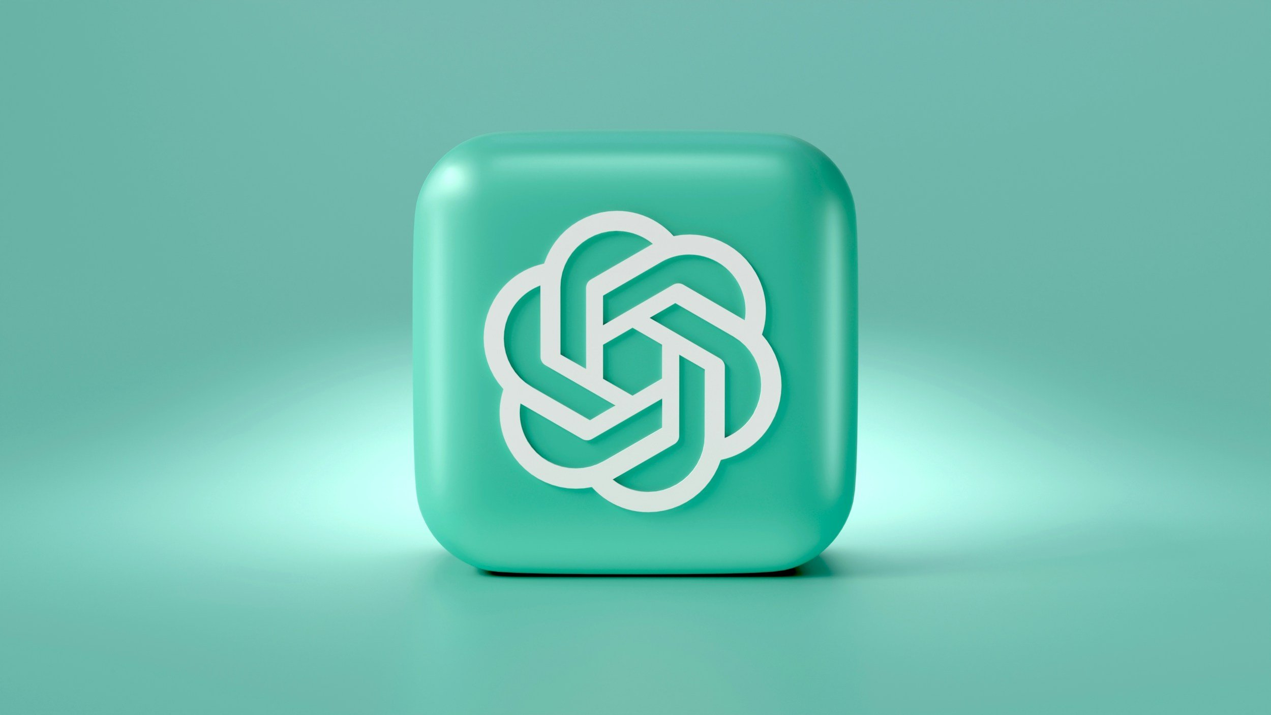 Aqua-colored 3D block featuring the OpenAI logo, set against a matching aqua background, symbolizing modern AI technology and design.