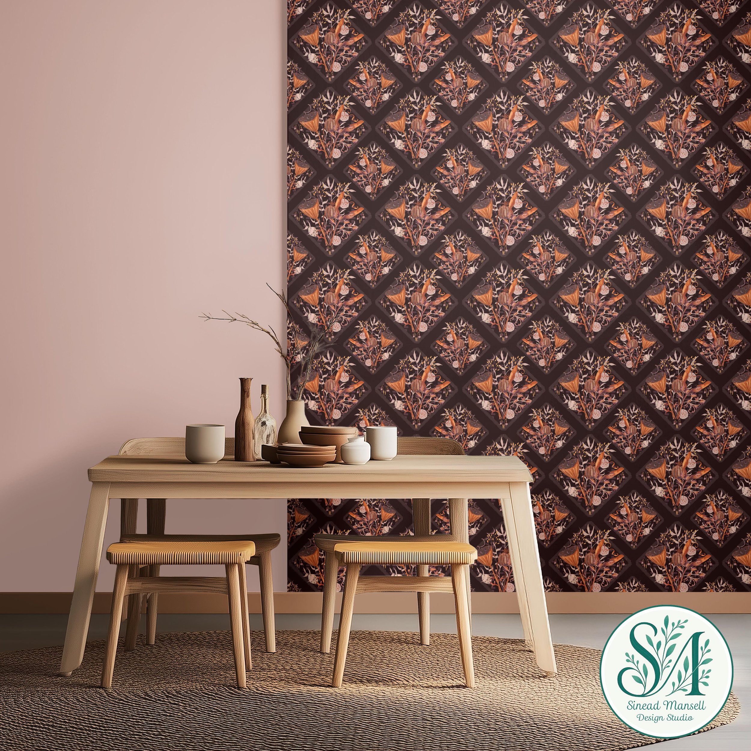 Interior scene with a light wood table, four matching chairs, and a dark patterned wall hanging with botanical and animal motifs, alongside decorative vases and dishware. A green and white logo of Sinead Mansell Design Studio is partially visible.