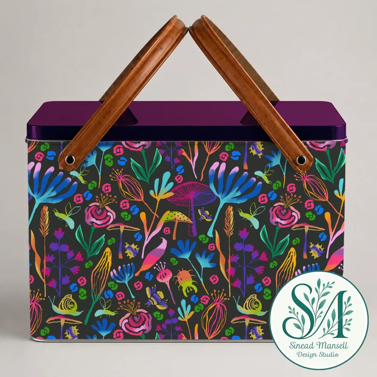 A colorful, floral-patterned box with wooden handles and a purple lid, against a plain background, featuring the Sinead Mansell Design Studio logo.
