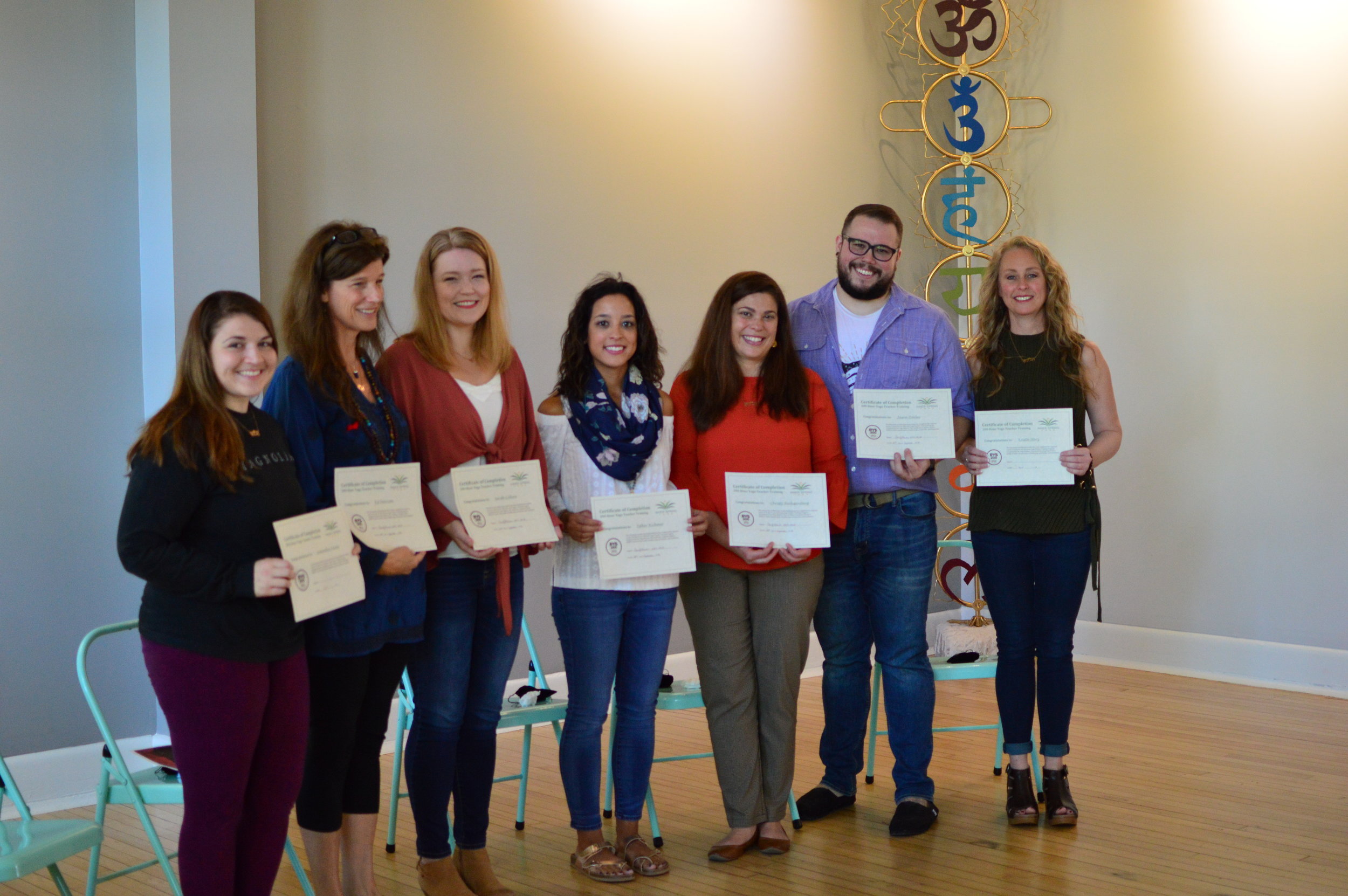 Photo of training session participants with their certification awards.