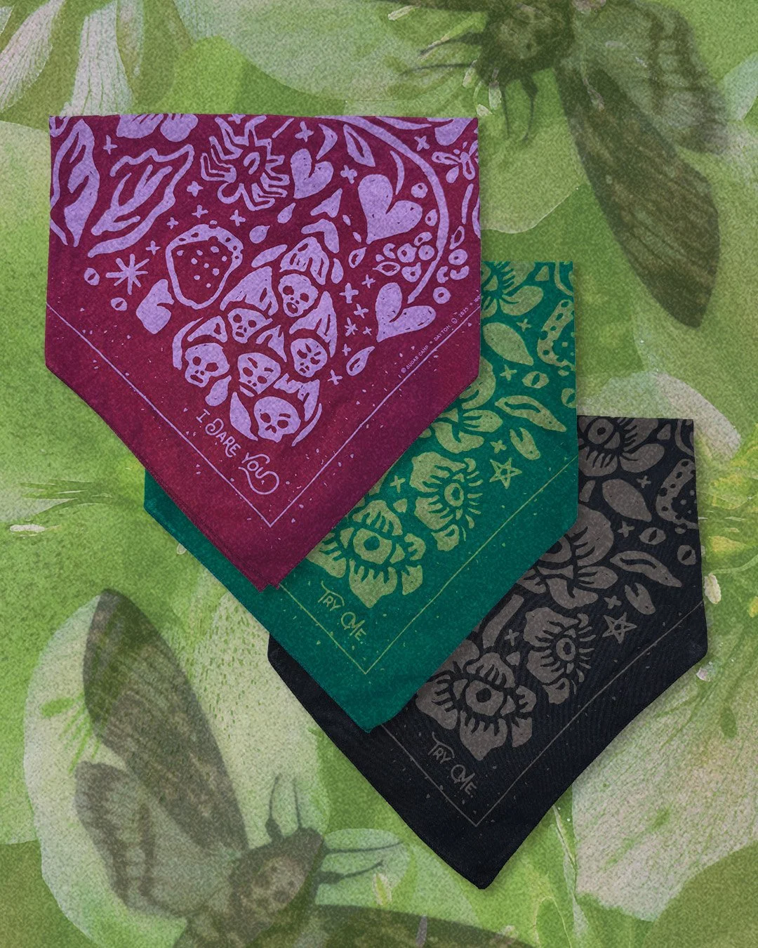Three Poisoner’s Garden bandanas in moss, berry, and black displayed together on a sour apple green floral hellebore background.