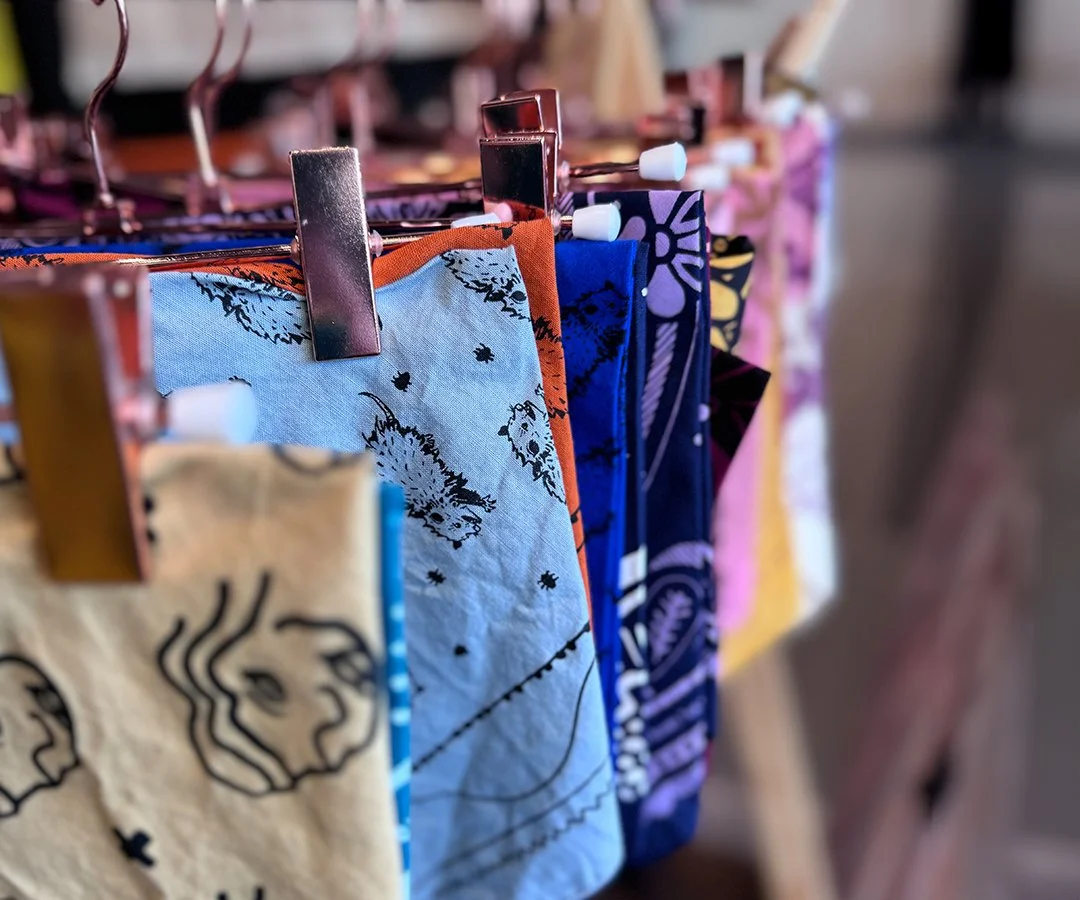 Sugar Camp Bandanas hung with copper hangers in retail display for wholesale. opossum bandana.